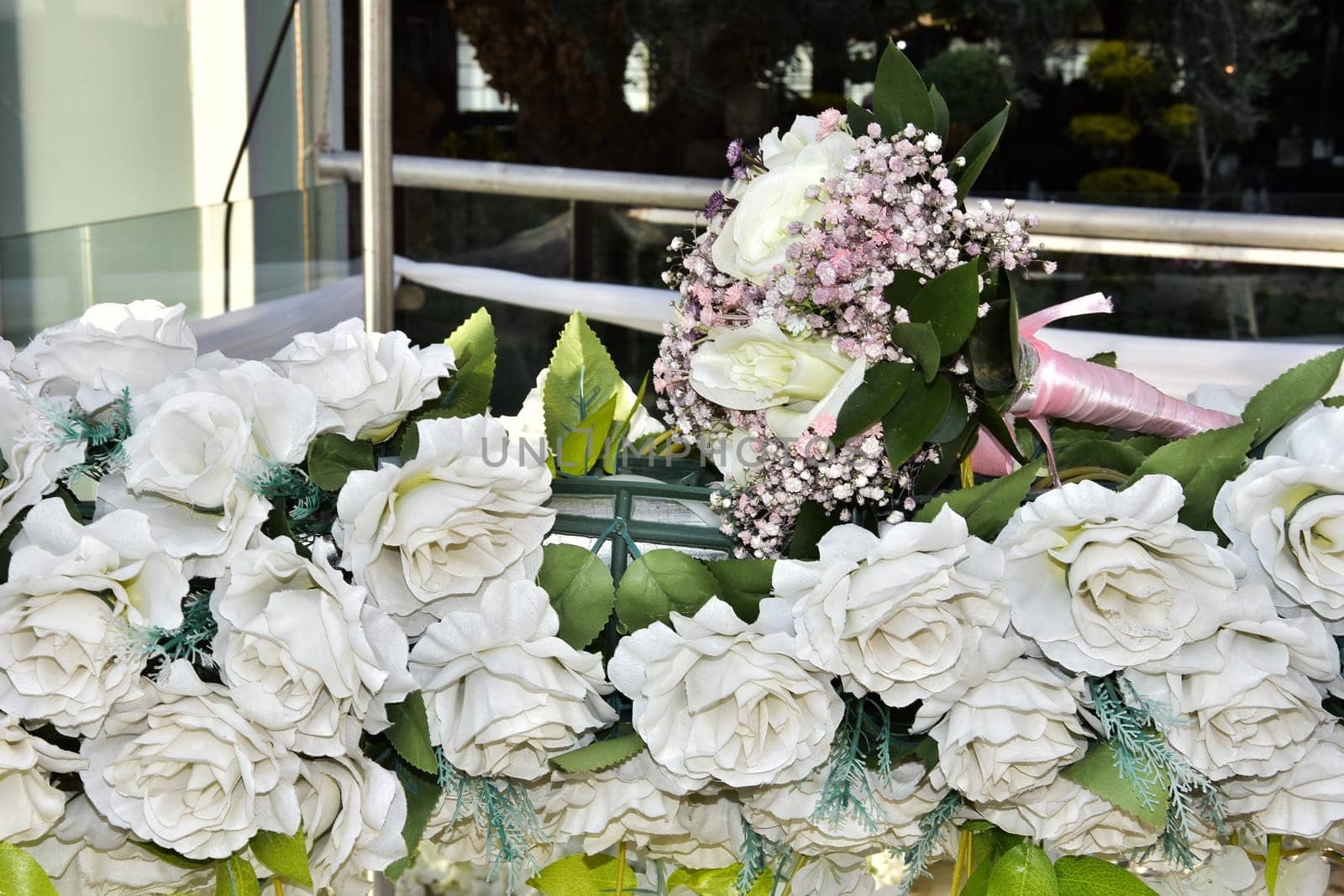 Wedding bridal bouquet of white roses and pink flowers lies on artificial decorative flowers. High quality photo