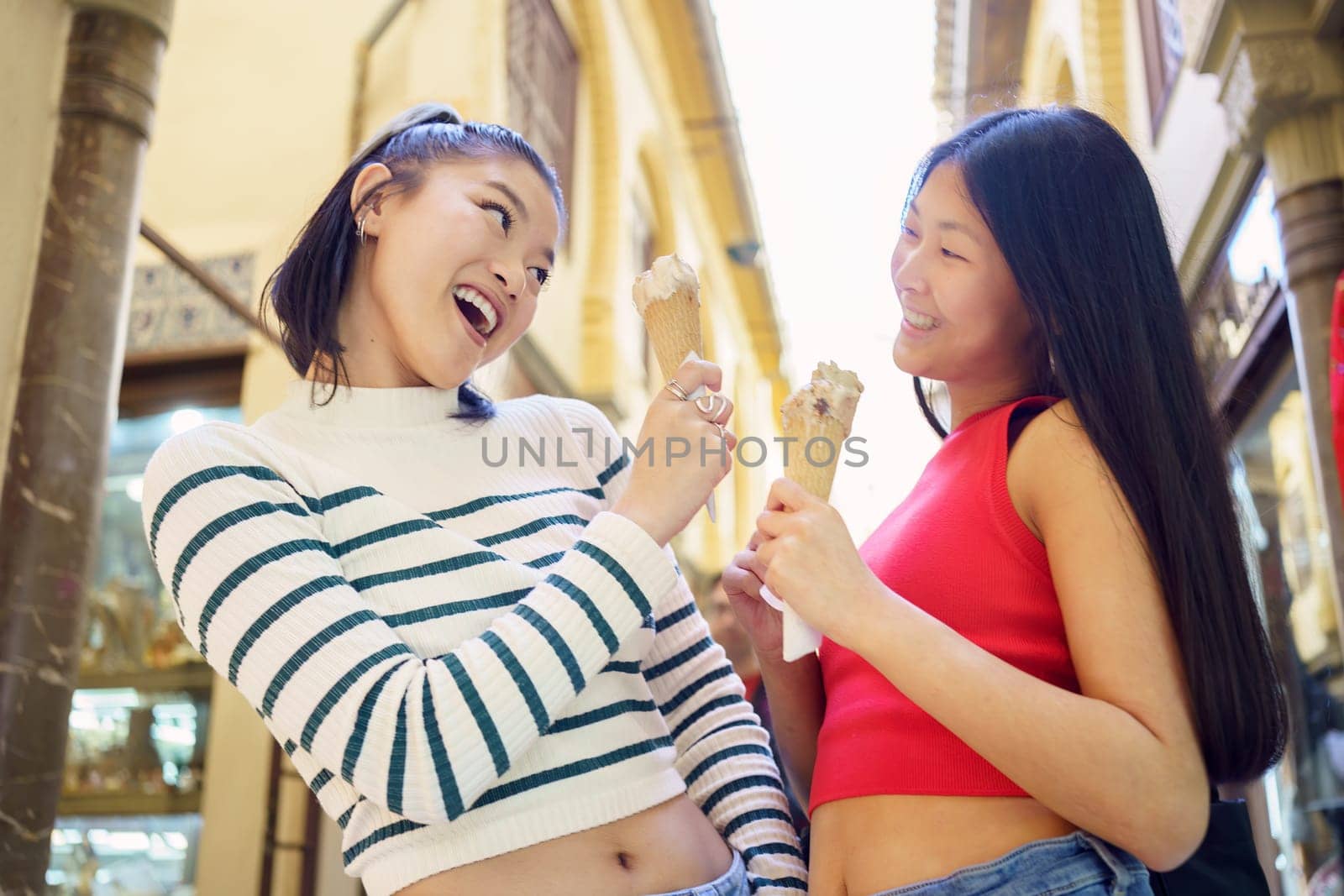 Smiling young Asian women with ice creams by javiindy