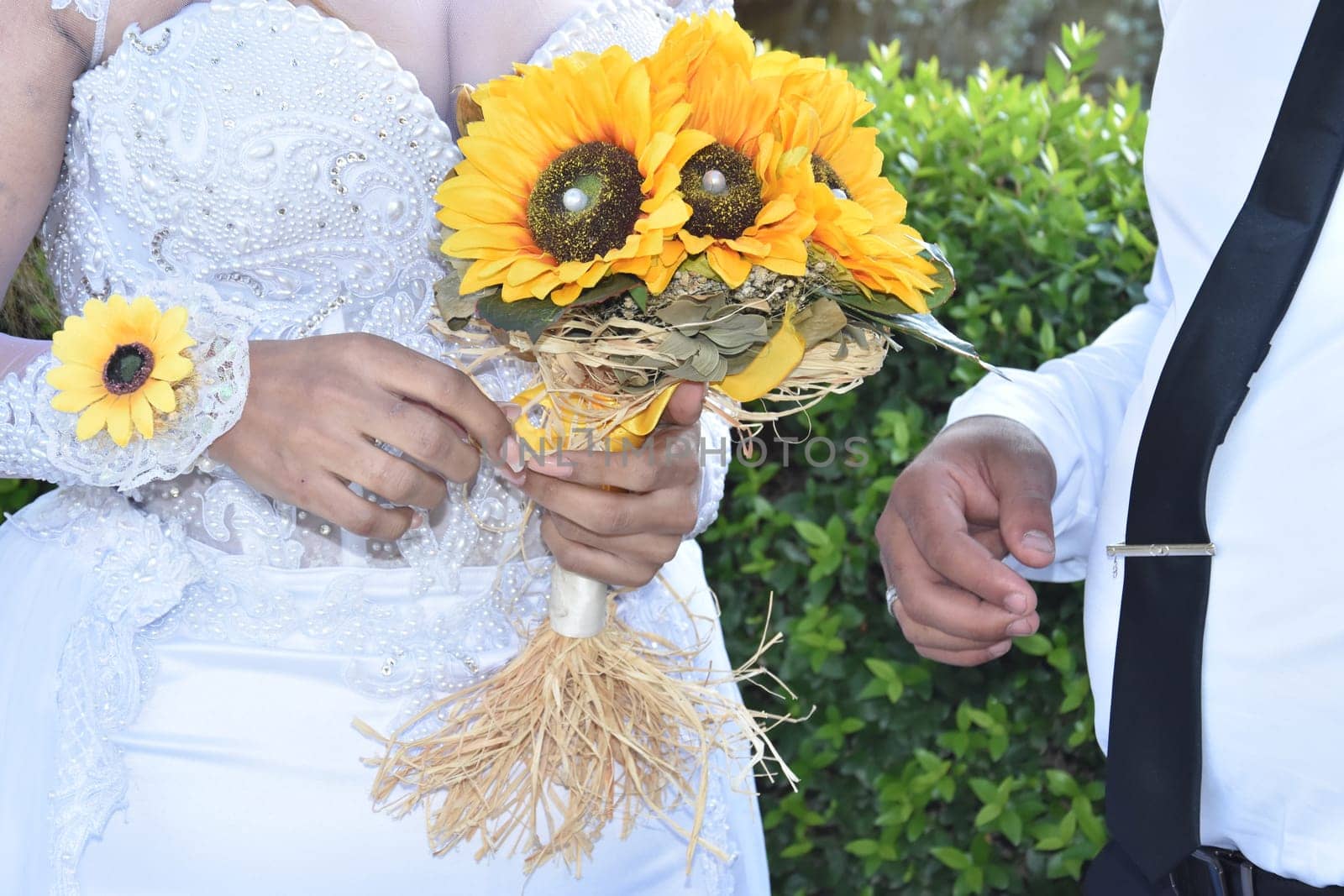 the groom's hands and nevsta with a bouquet of yellow flowers, a gold wedding ring. High quality photo