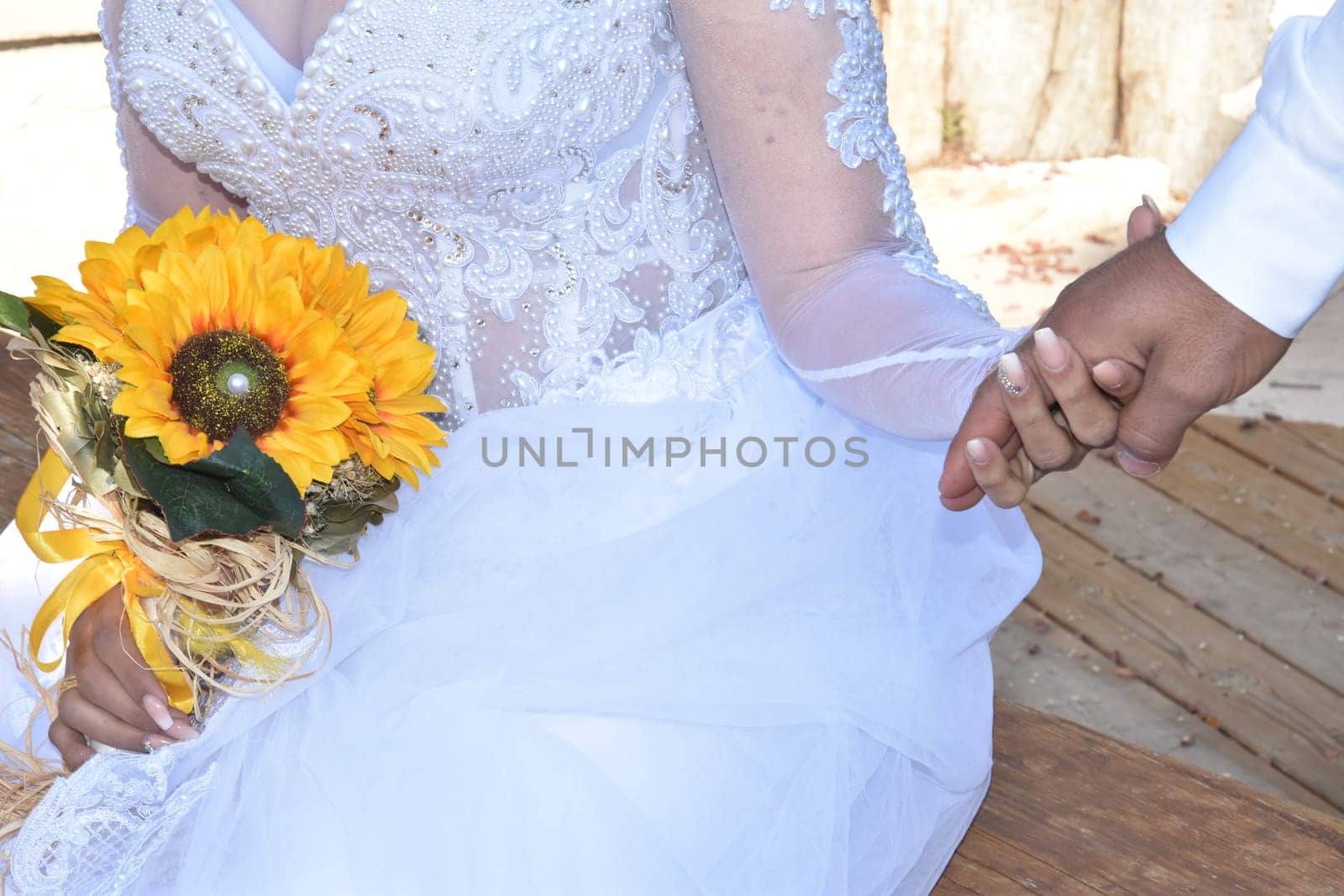 hands of newlyweds with gold wedding rings, yellow flowers. High quality photo