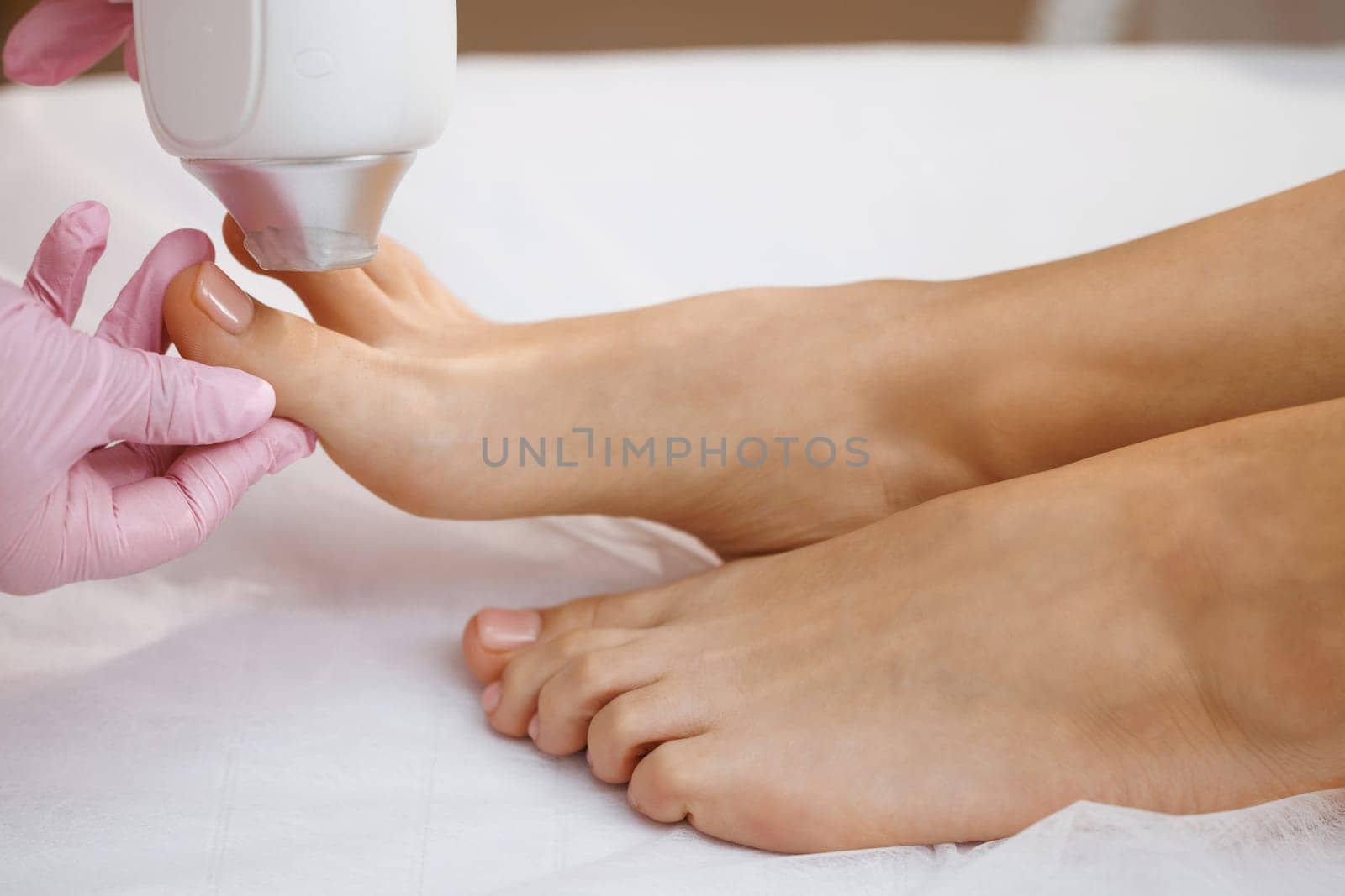 Woman doing laser epilation procedure, closeup view. Laser hair removal and cosmetology. Cosmetic hair removal procedure. Cosmetology and SPA concept.