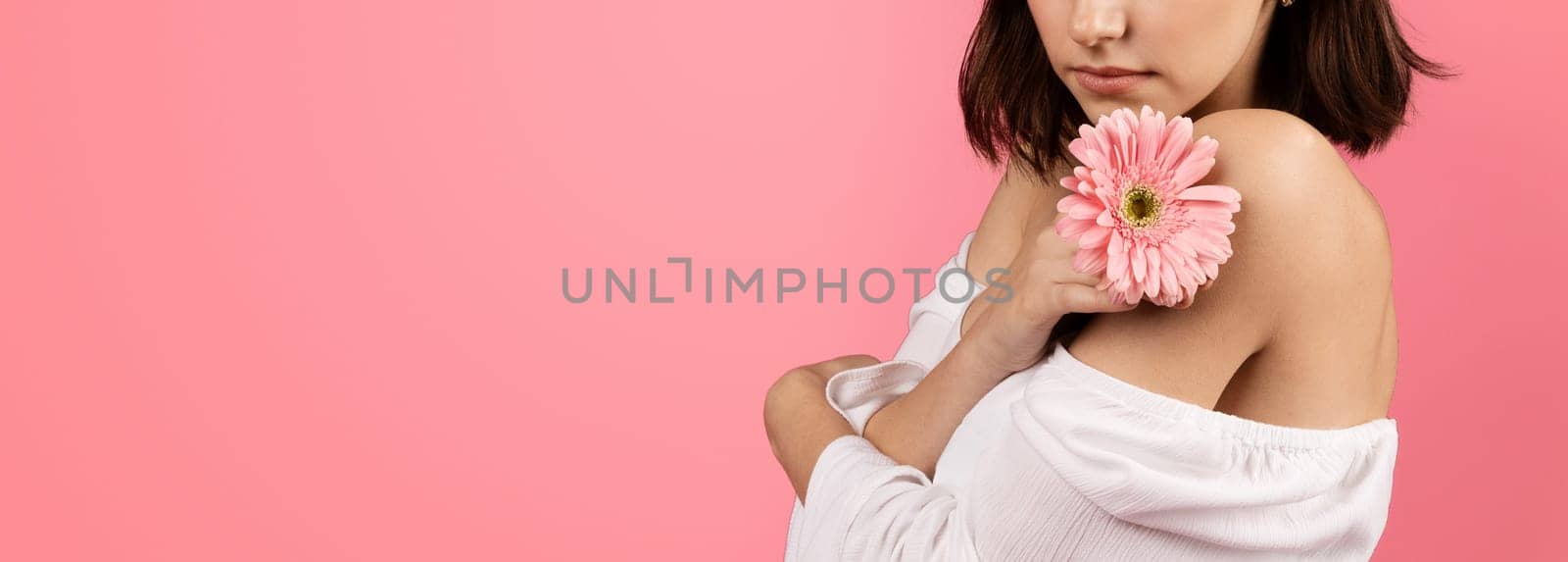 Serious calm millennial caucasian brunette woman enjoy flower, isolated on pink background, studio, cropped, panorama. Ad and offer, lifestyle, beauty care and health care
