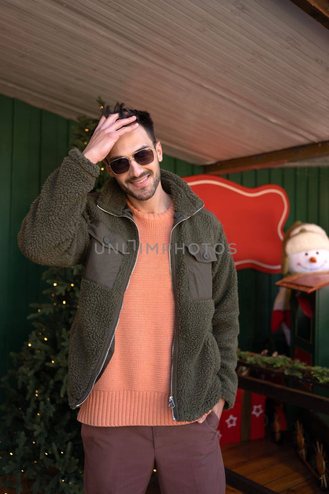 Handsome man wearing sunglasses standing outside fix hairstyle looking camera and smiling. Close up portrait young bearded male person, vertical photo