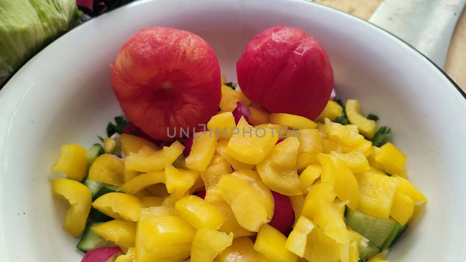 fresh salad of yellow sweet peppers and tomato, vegetables food in a white bowl products, red-yellow background. High quality photo