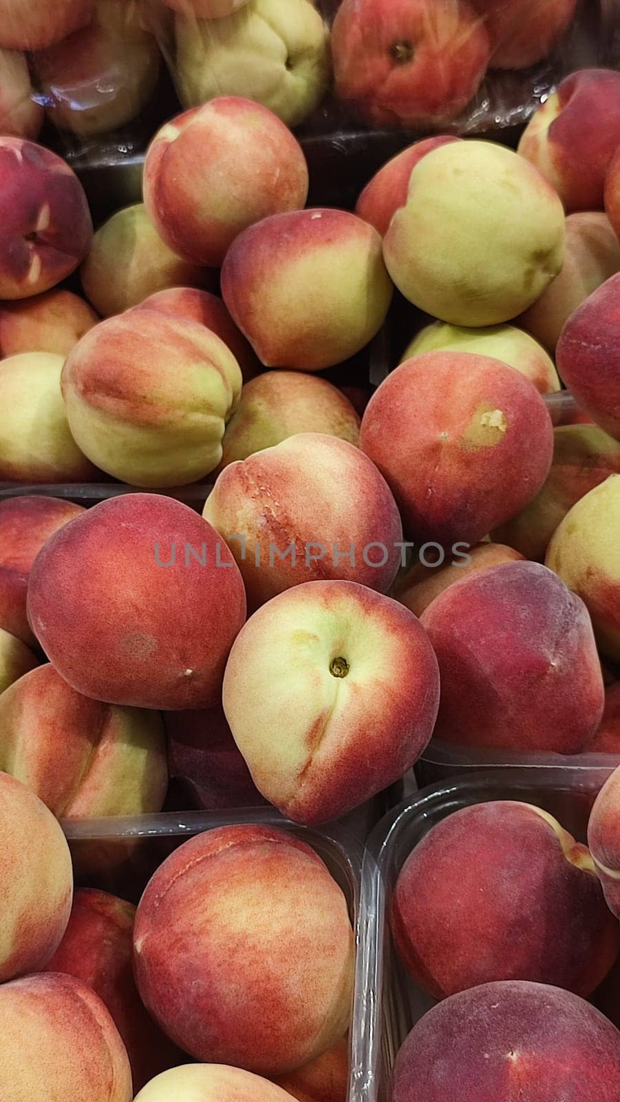 fresh peaches fruits, food in the grocery store, red-yellow background. High quality photo