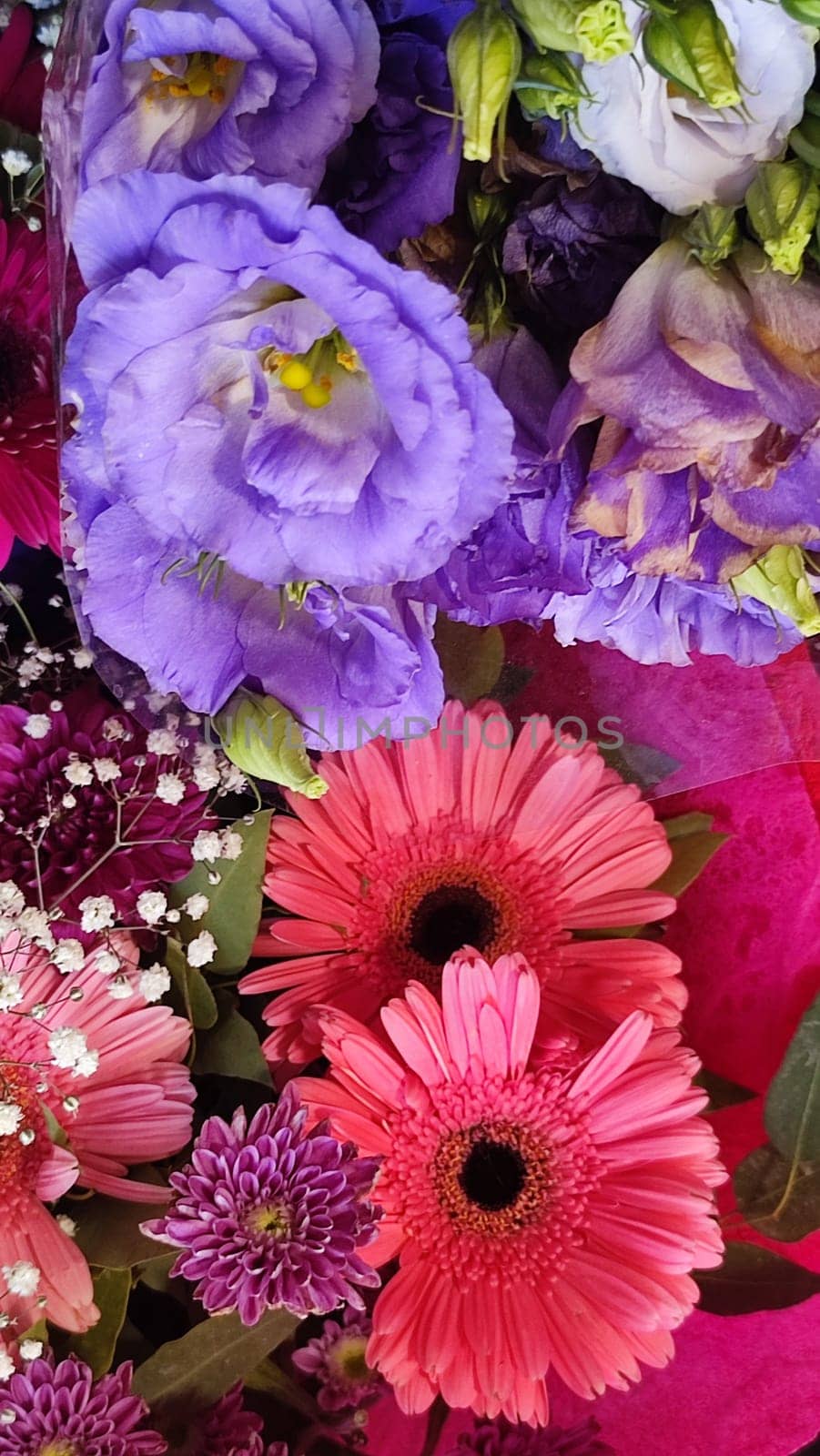 pink gerbera flowers and white lilies in a bouquet, plant shop. High quality photo