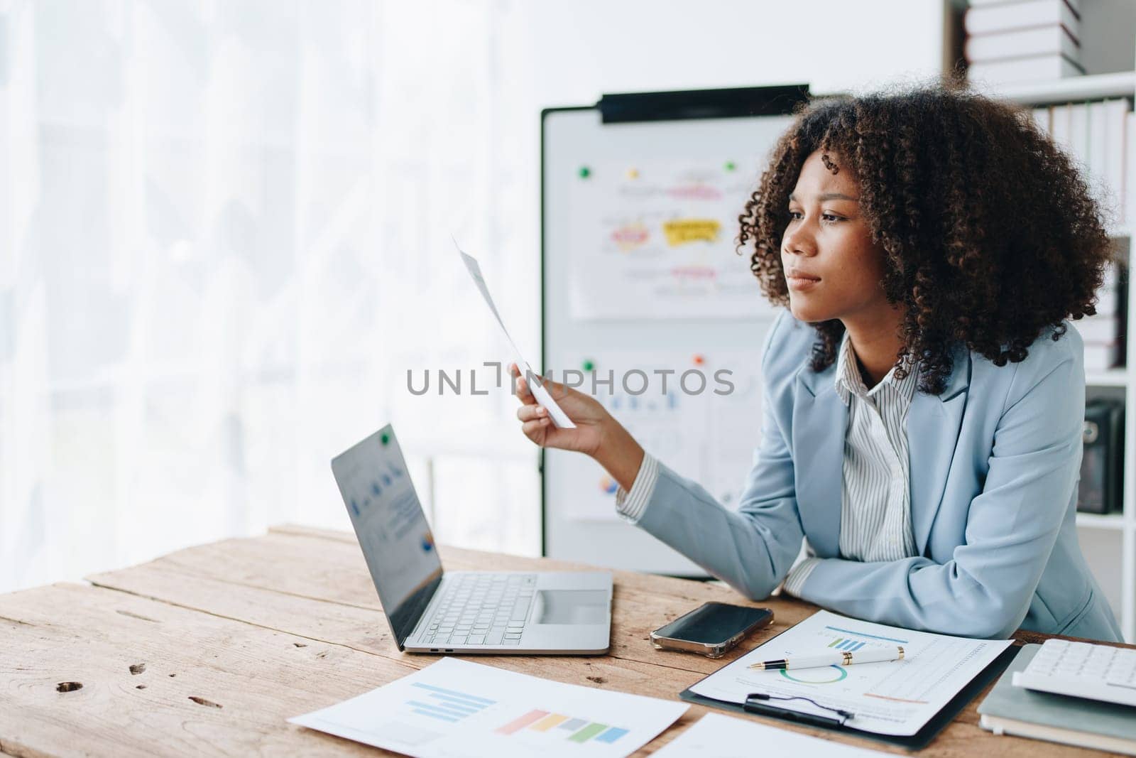 Burnout American African business woman in stress works with many paperwork document, migraine attack, Freelance, work at office.