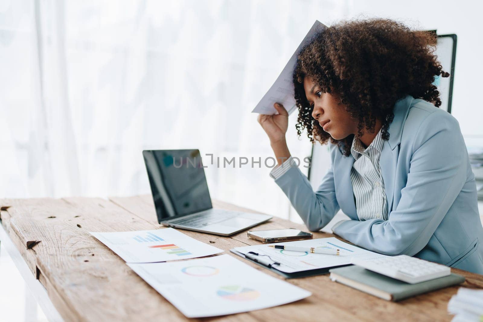 Burnout American African business woman in stress works with many paperwork document, migraine attack, Freelance, work at office.