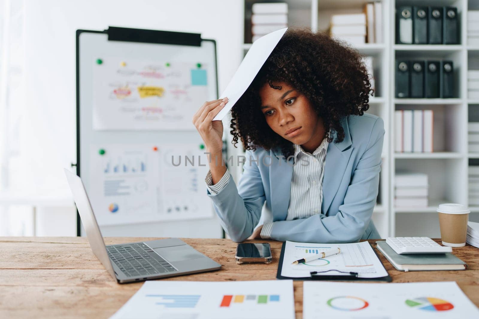 Burnout American African business woman in stress works with many paperwork document, migraine attack, Freelance, work at office.