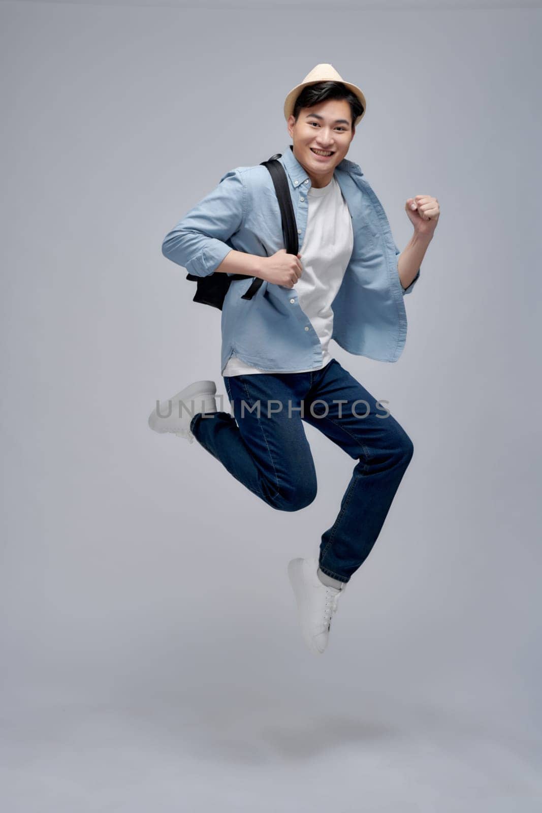 screaming man running jumping towards airport in white shoes and satchel in hands 