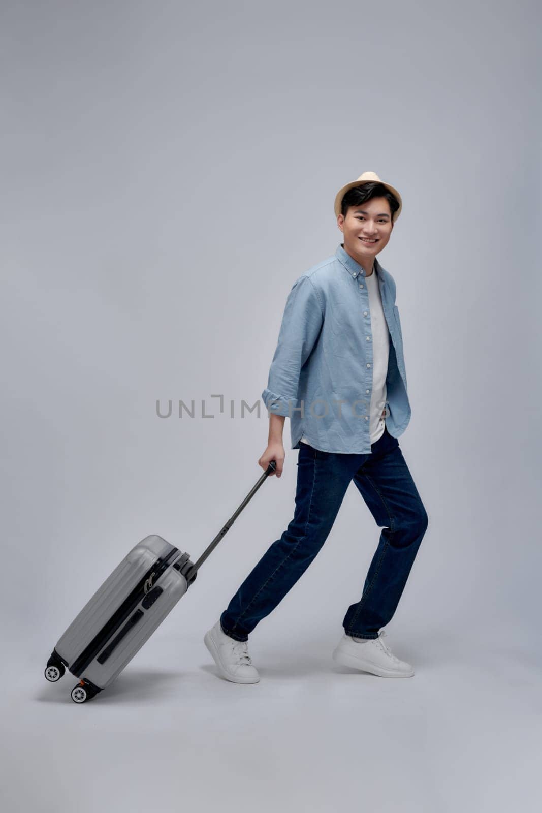 Male tourist with suitcase walking going on vacation advertising travel offer by makidotvn