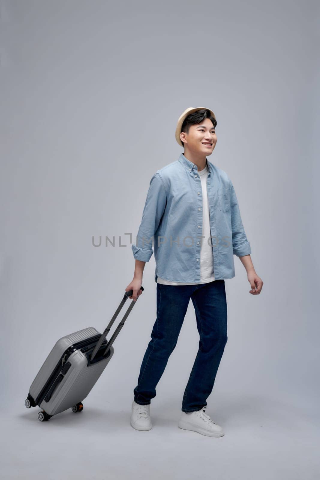 Male tourist with suitcase walking going on vacation advertising travel offer by makidotvn