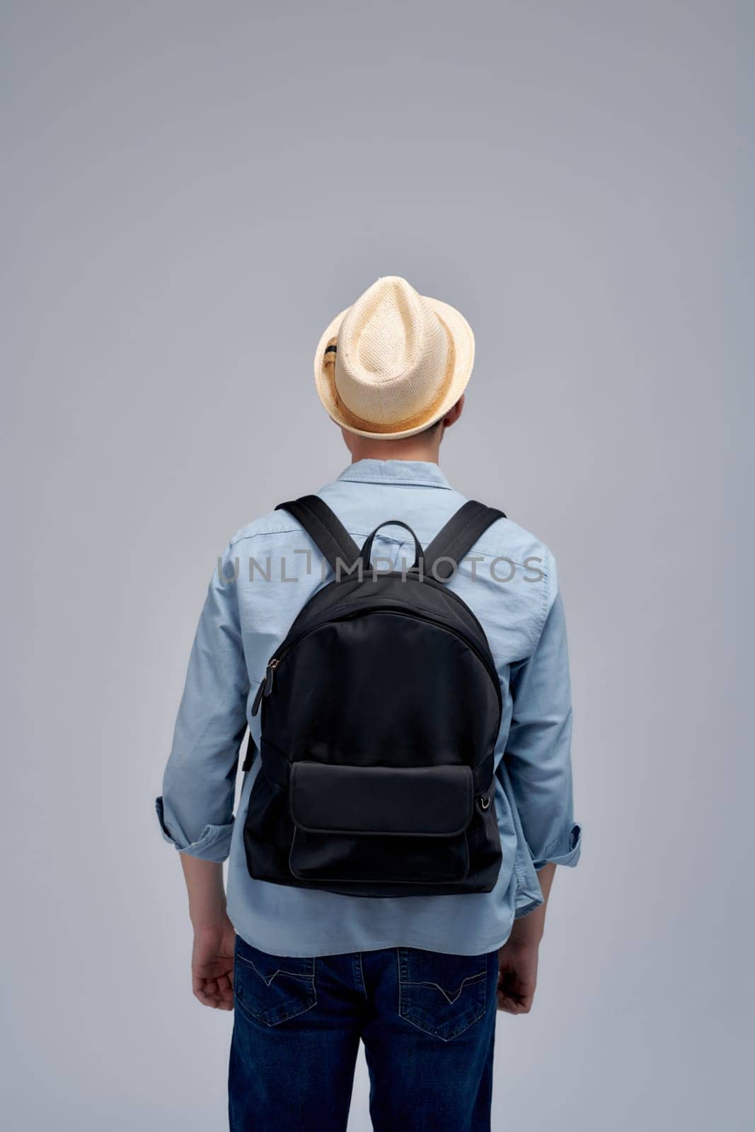 Young traveler wearing a hat with backpack on white background