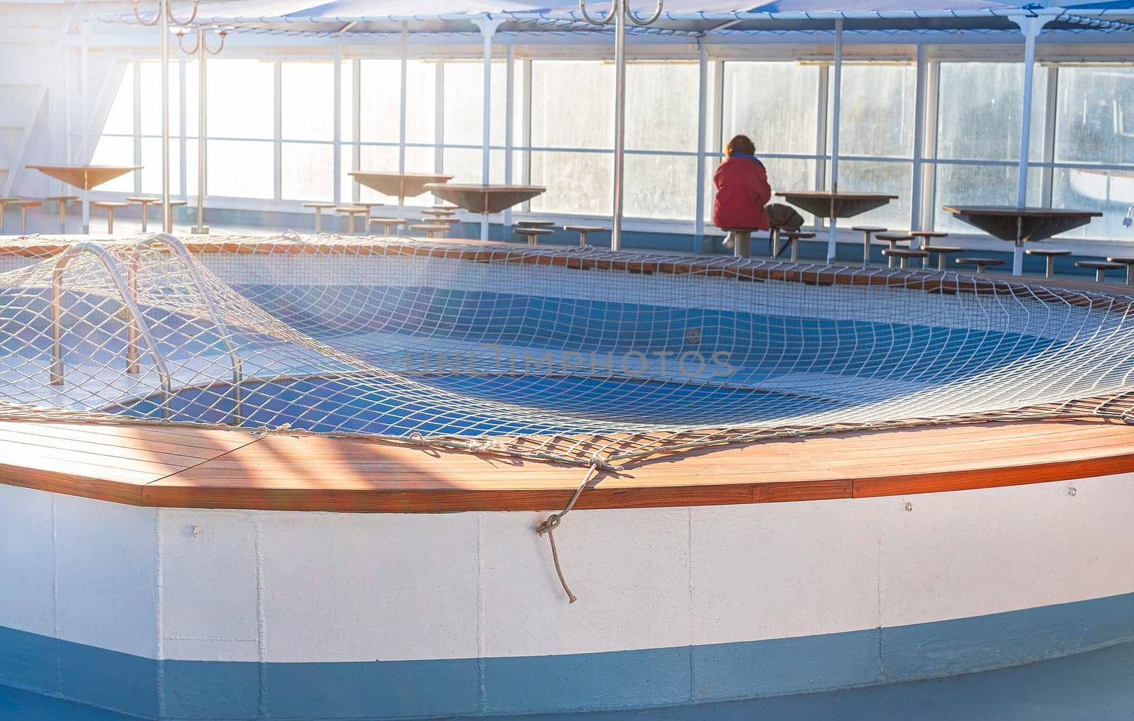 A lonely man in red relaxing at the table of a cruise ship - travel and vacation concept.