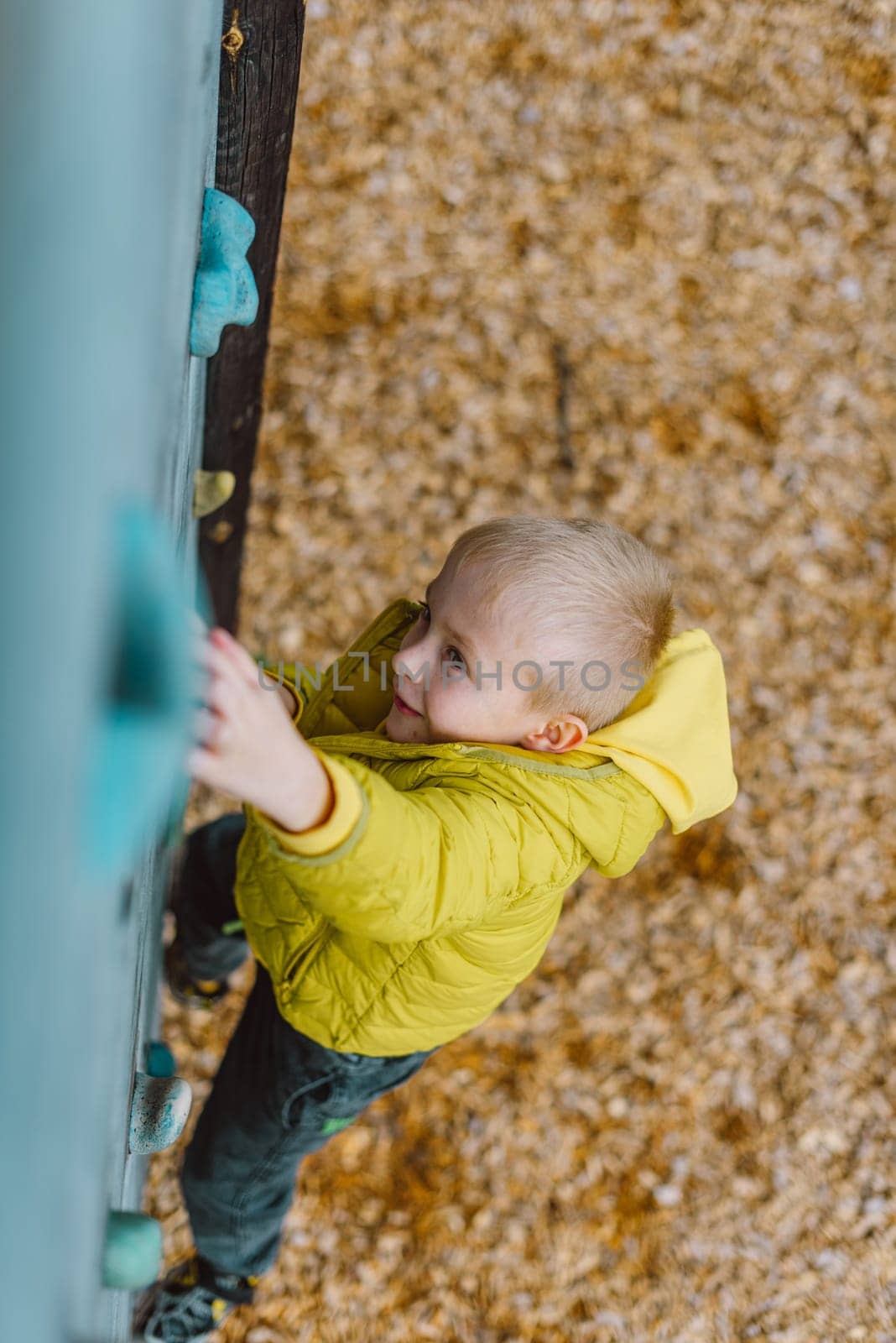 Boy at the climbing wall without a helmet, danger at the climbing wall.