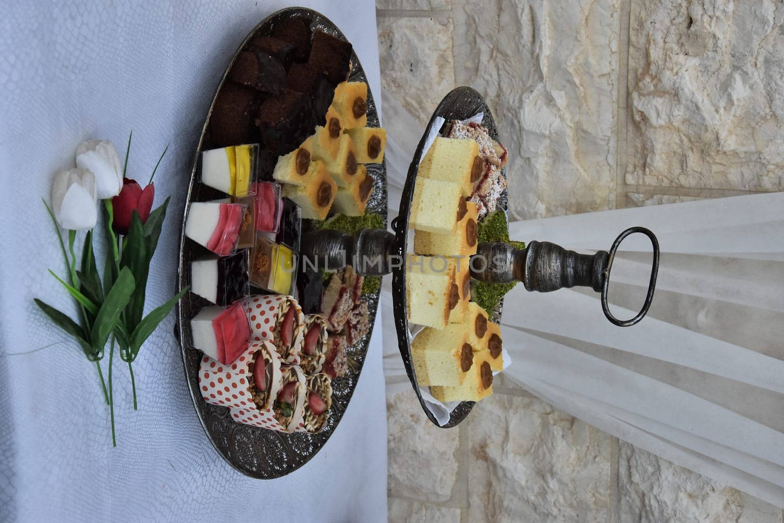 festive dessert on dishes, table with white tablecloth against the wall. High quality photo