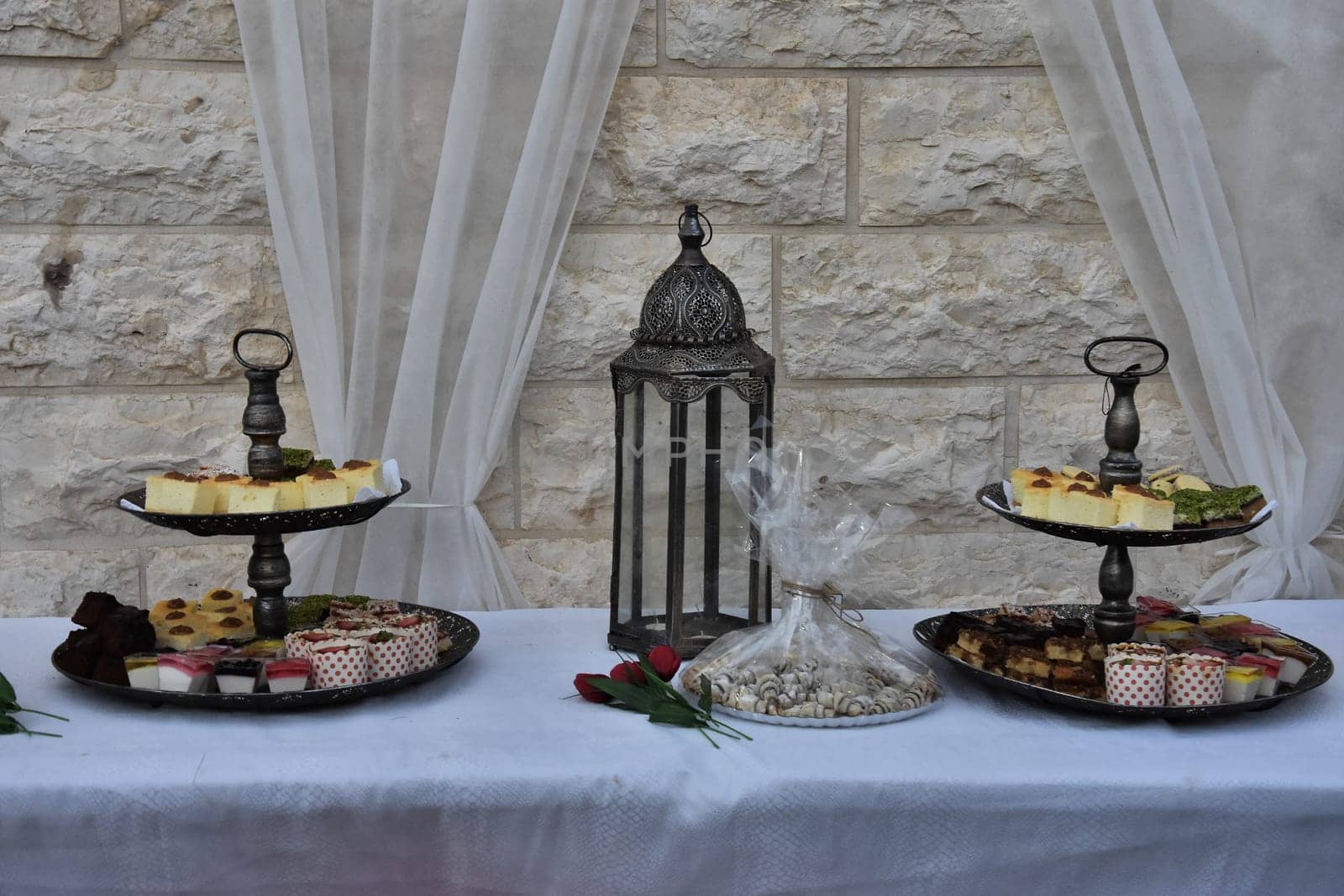 festive dessert on dishes, table with white tablecloth against the wall. High quality photo