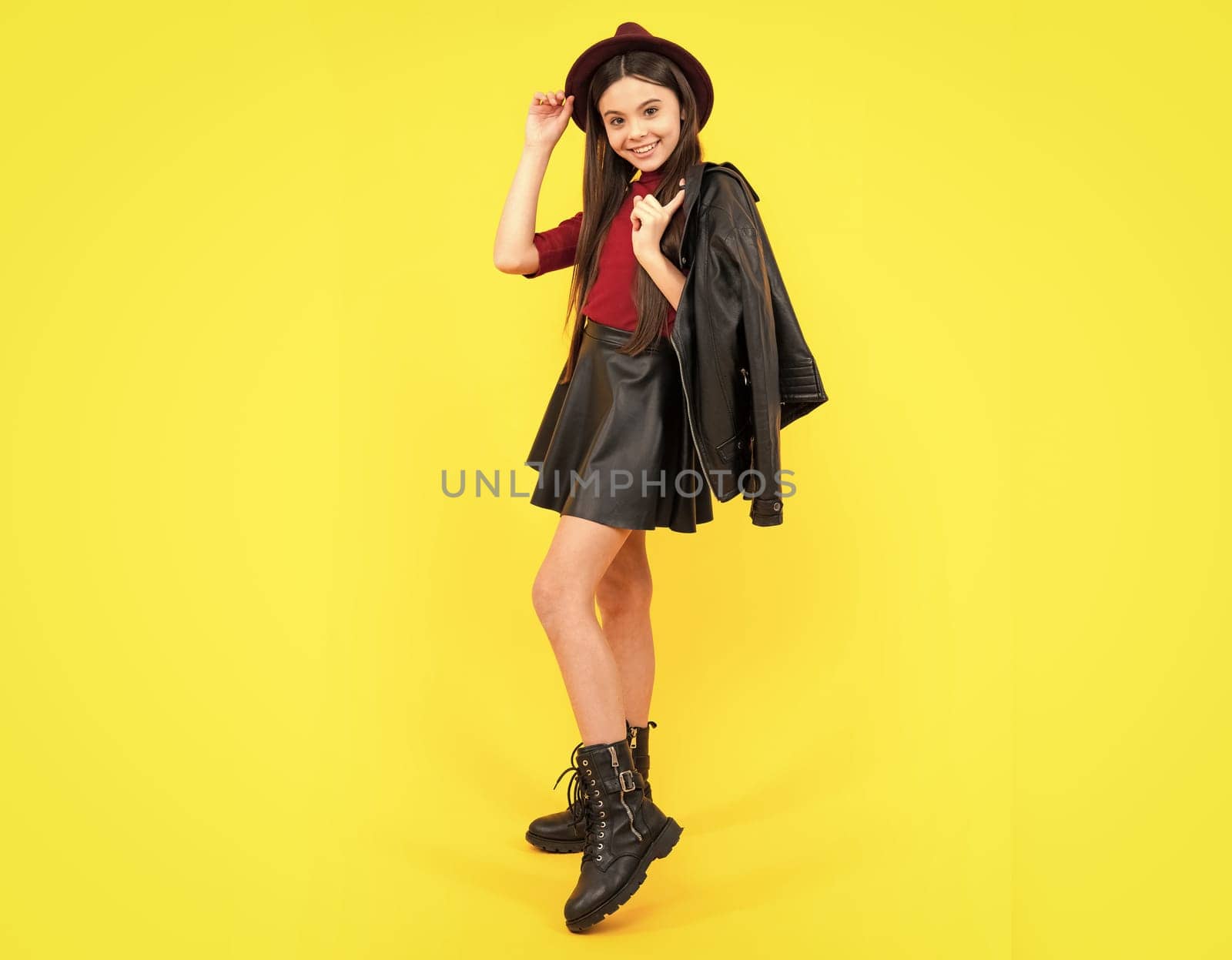 Full length photo of pretty teenager child girl wear casual clothes leather skirt isolated on yellow background. Happy teenager portrait. Smiling girl