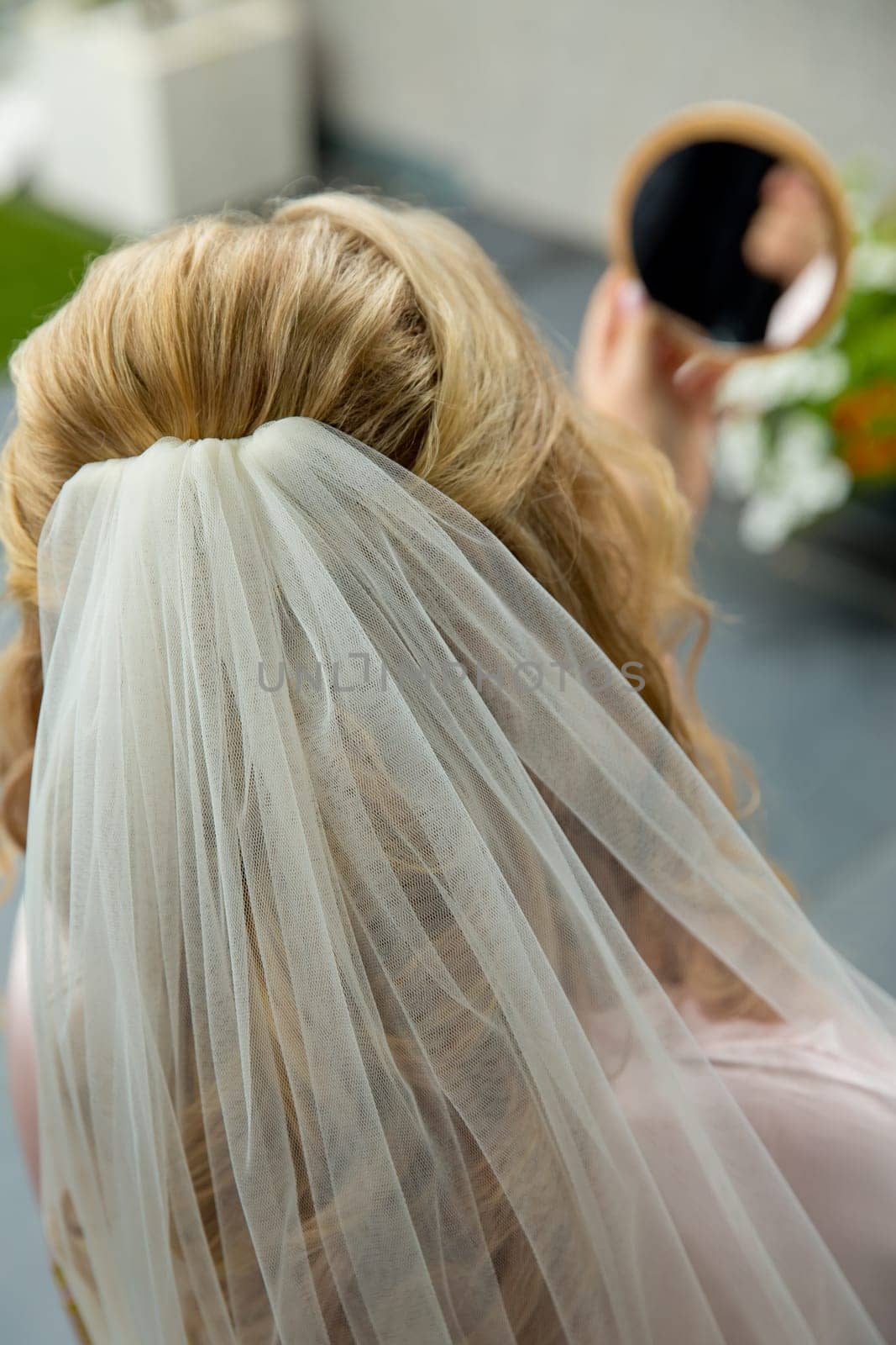 The bride looks in the mirror. No face.