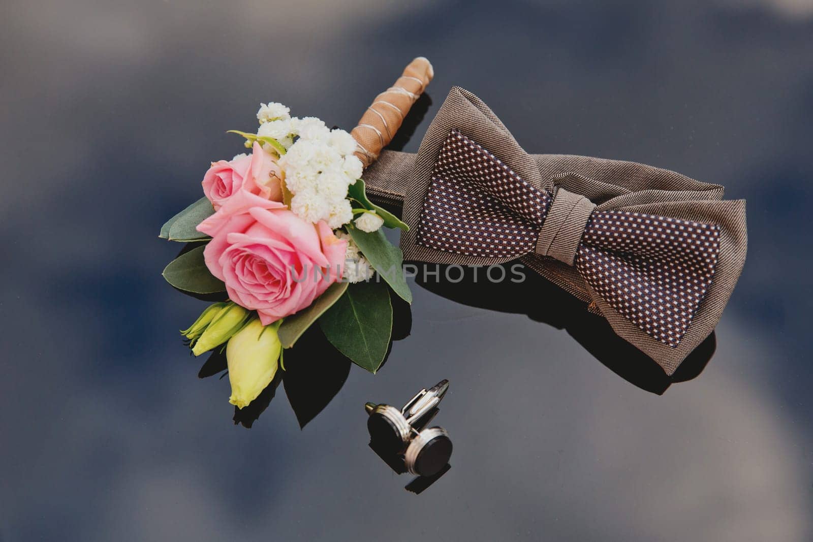 Set groom accessories. Boutonniere, bow tie, cufflinks. Soft focus.