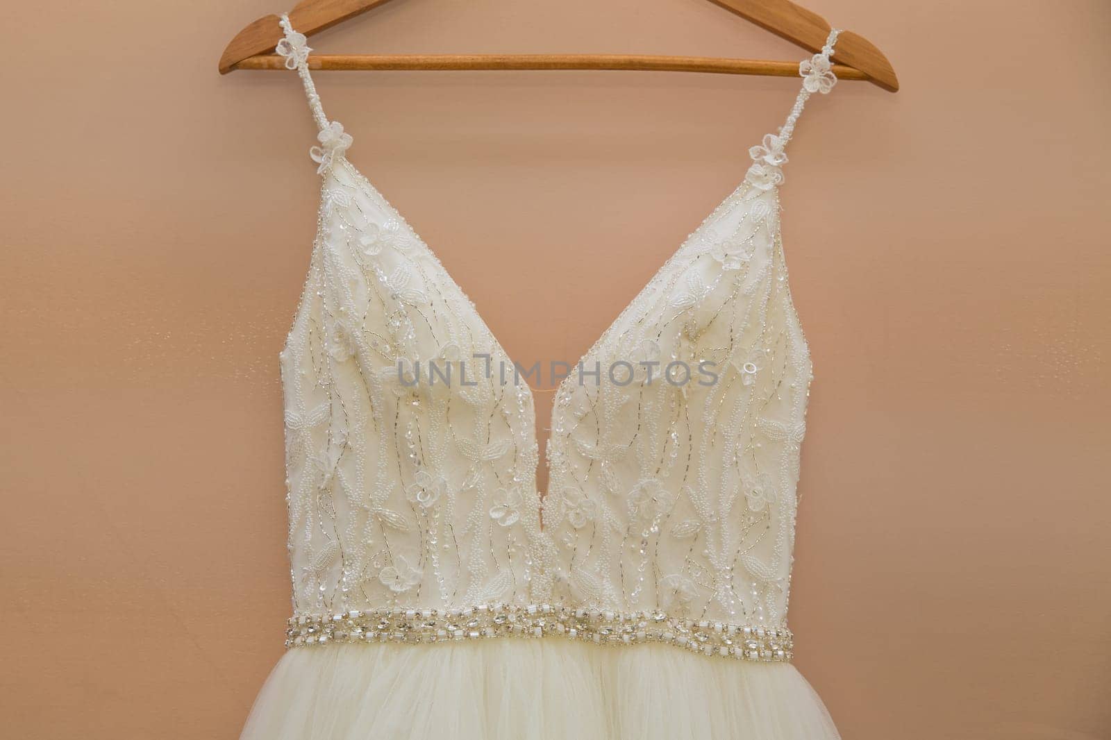 The delicate bride's dress is hanging in room. Selective focus. Close-up.