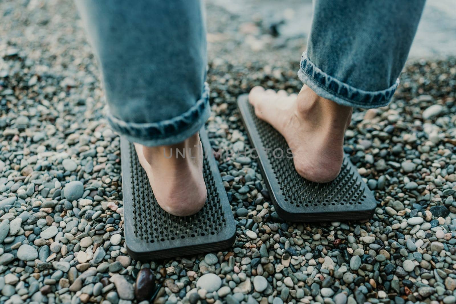 Sea Woman feet stepping on sadhu board during indian practice on the seashore. . Healthy lifestyle concept. tool for working out your inner state.