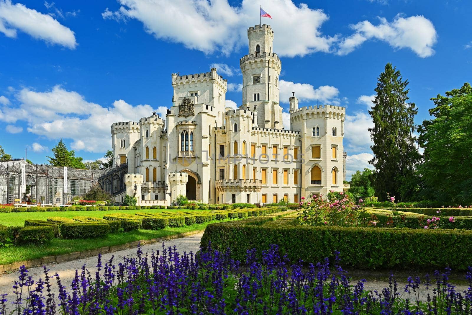 Beautiful old state chateau Hluboká nad Vltavou. View from the outdoor garden in summer with blue sky, sun and clouds.