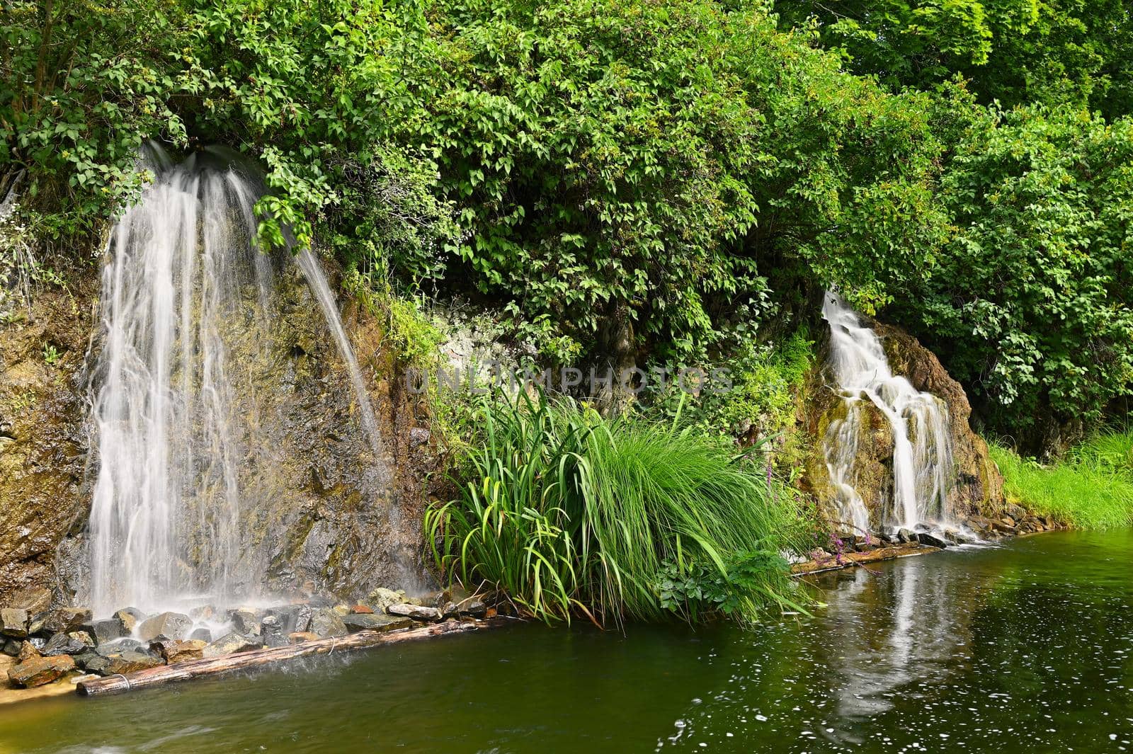 Beautiful small waterfall with a rock in nature. Brno castle Spilberk.