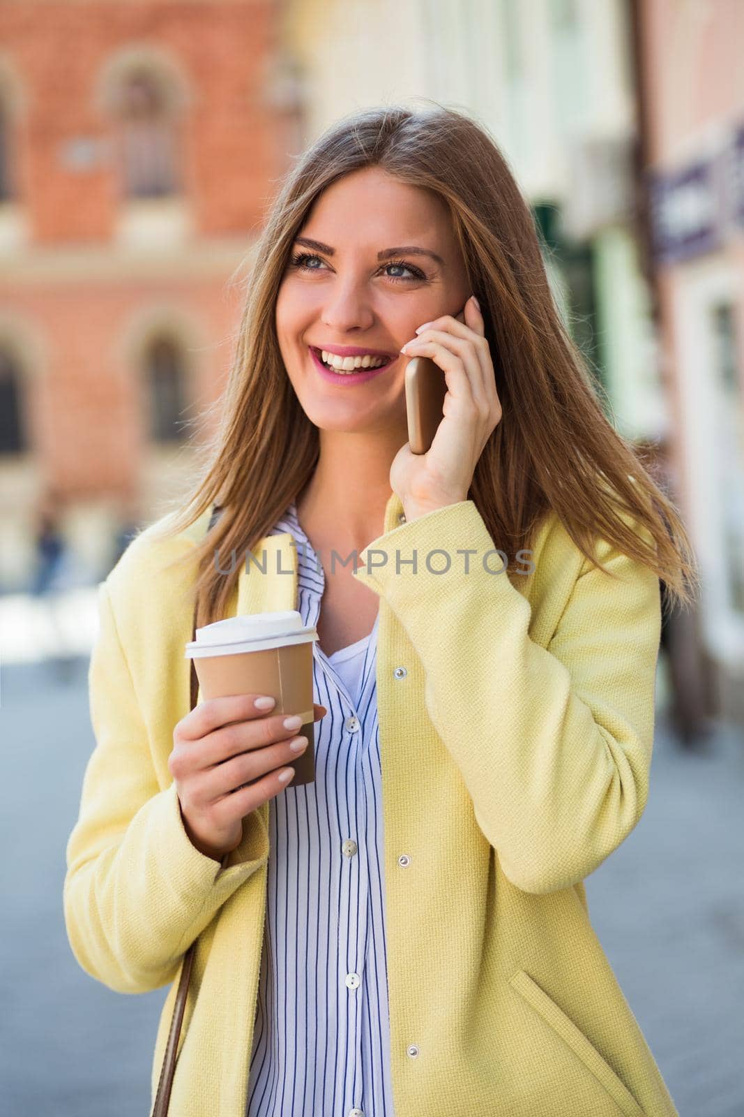 Businesswoman talking on the phone and drinking coffee by Bazdar