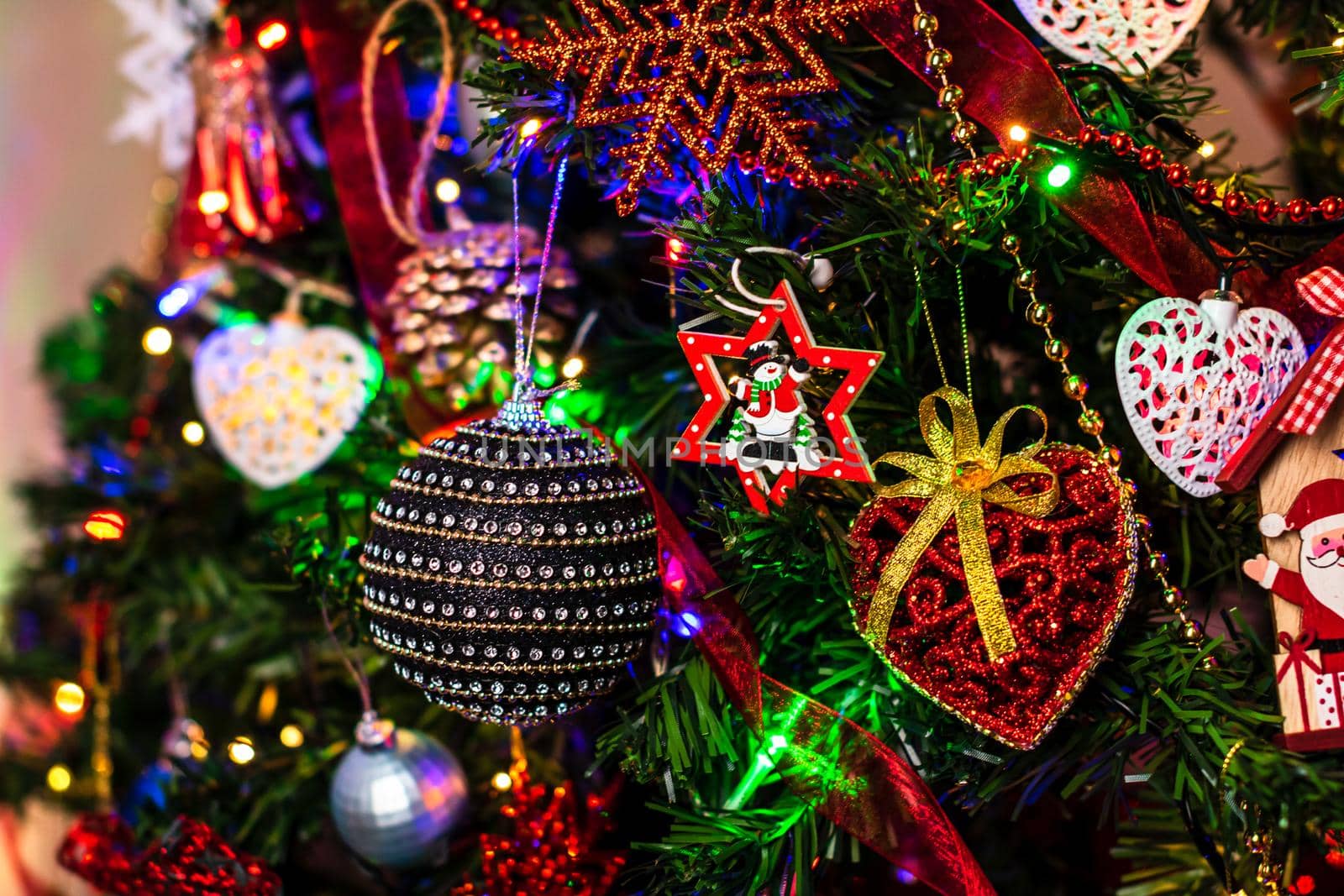 Beautiful Christmas ornaments and lights hanging in the Christmas tree by vladispas