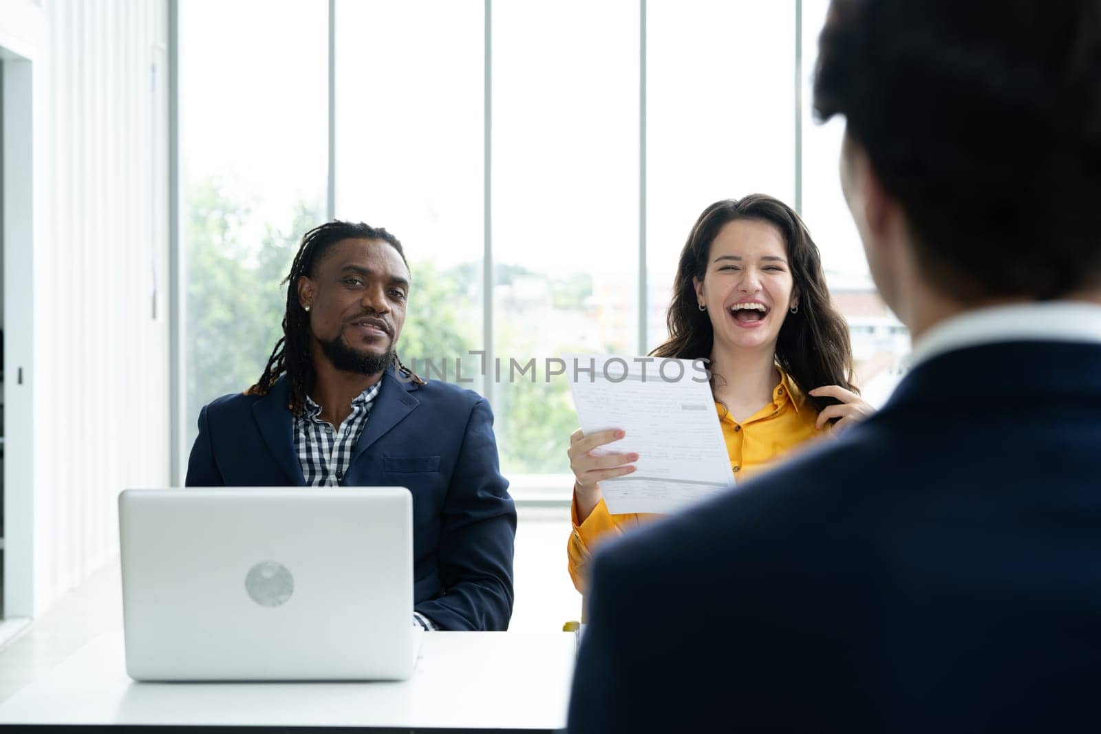 Job interview concept. Diverse hr team doing job interview with a man in business office. Happy business people working in office. Hiring and recruitment concept. Positive business office meeting. 