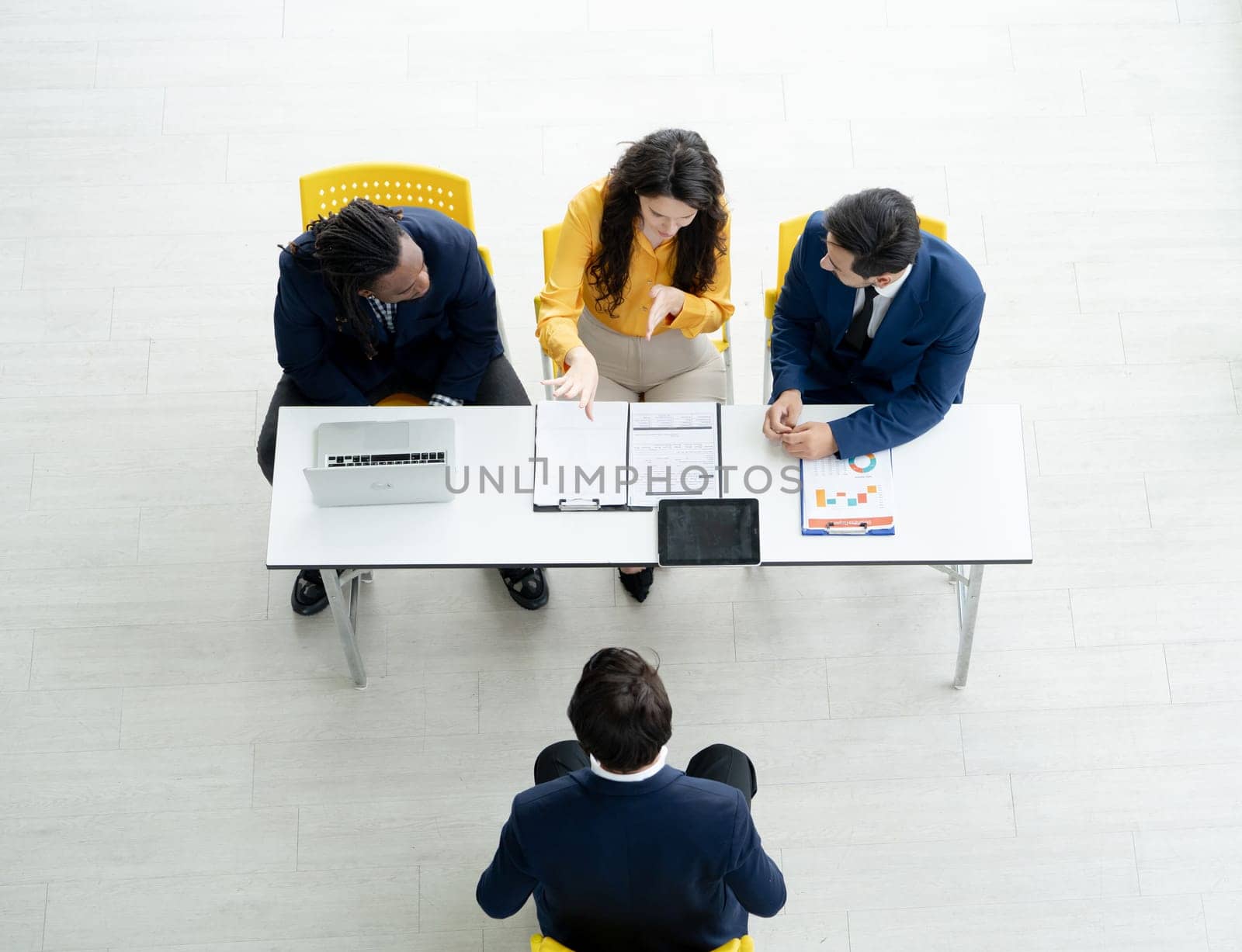 Job interview concept. Diverse hr team doing job interview with a man in business office. Human resources team interviewing a potential job candidate. Hiring, employment, and recruitment concept. by Fahroni