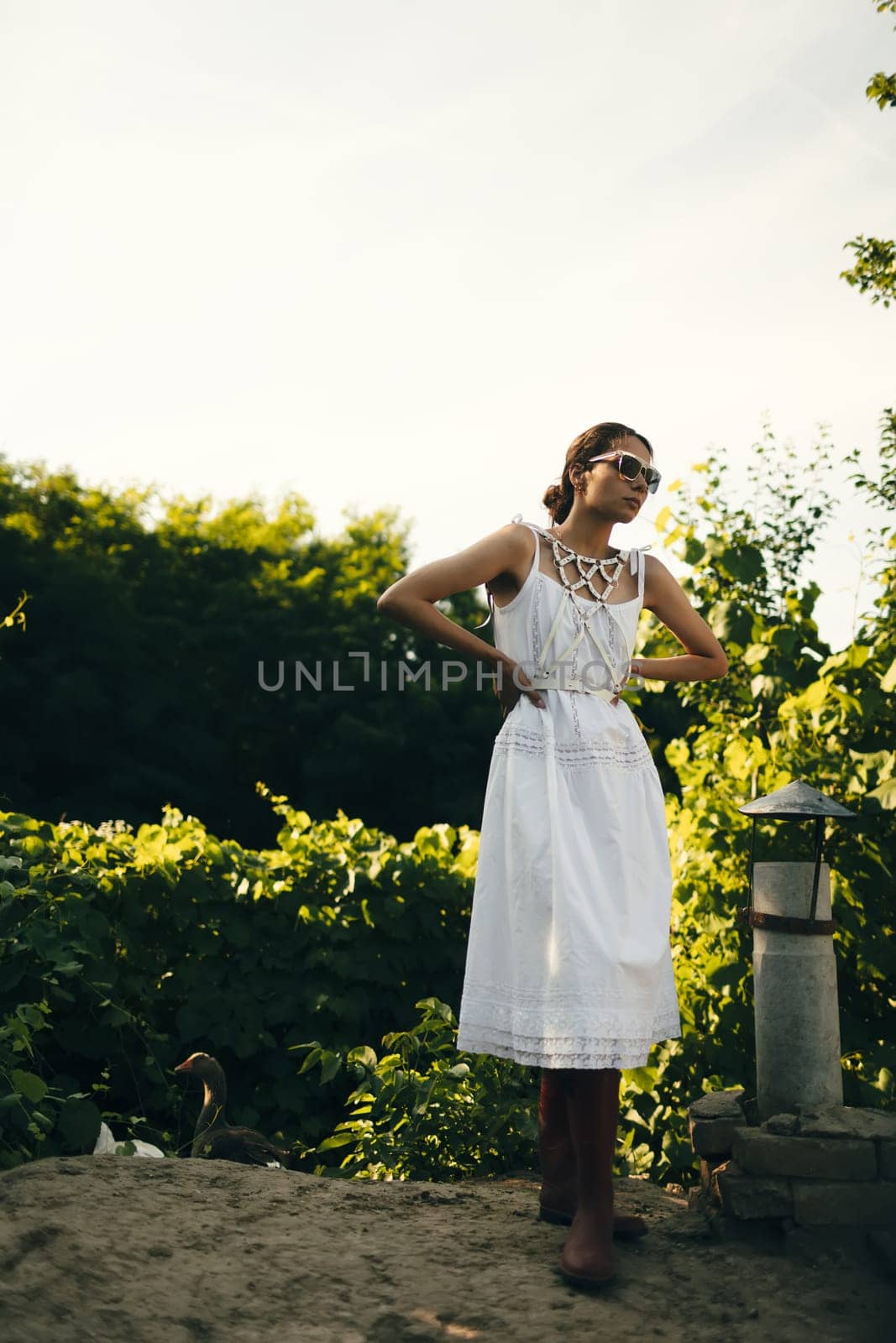 Portrait of a beautiful girl in a white dress in the garden. Burnette beautiful natural girl with in a white dress in nature, on the street, in the garden by a tree, with makeup and hairstyle. by sarymsakov