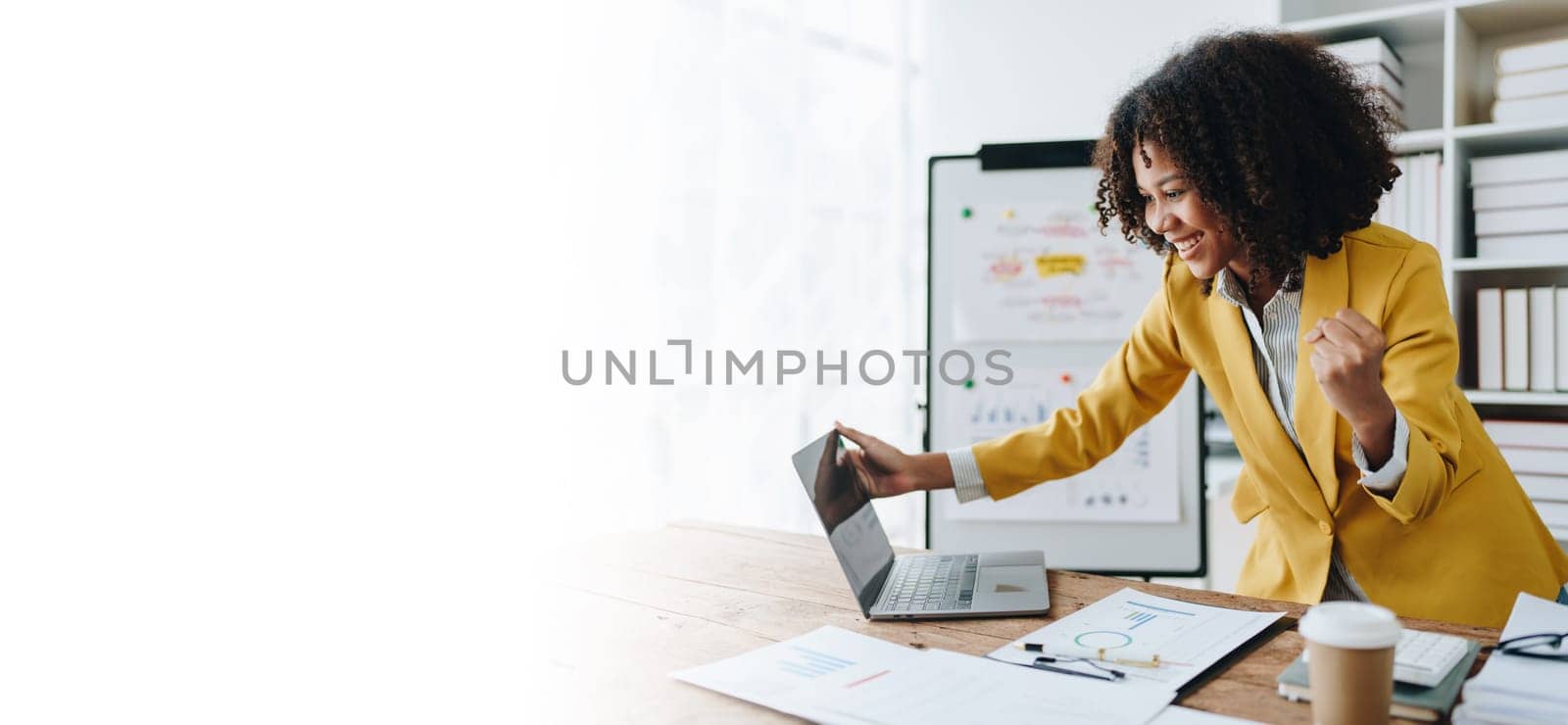 American African business woman using document, computer laptop, calculator, paperwork, documents, in winner and smiling Happy to be successful achievement success. finance and investment concepts by Manastrong