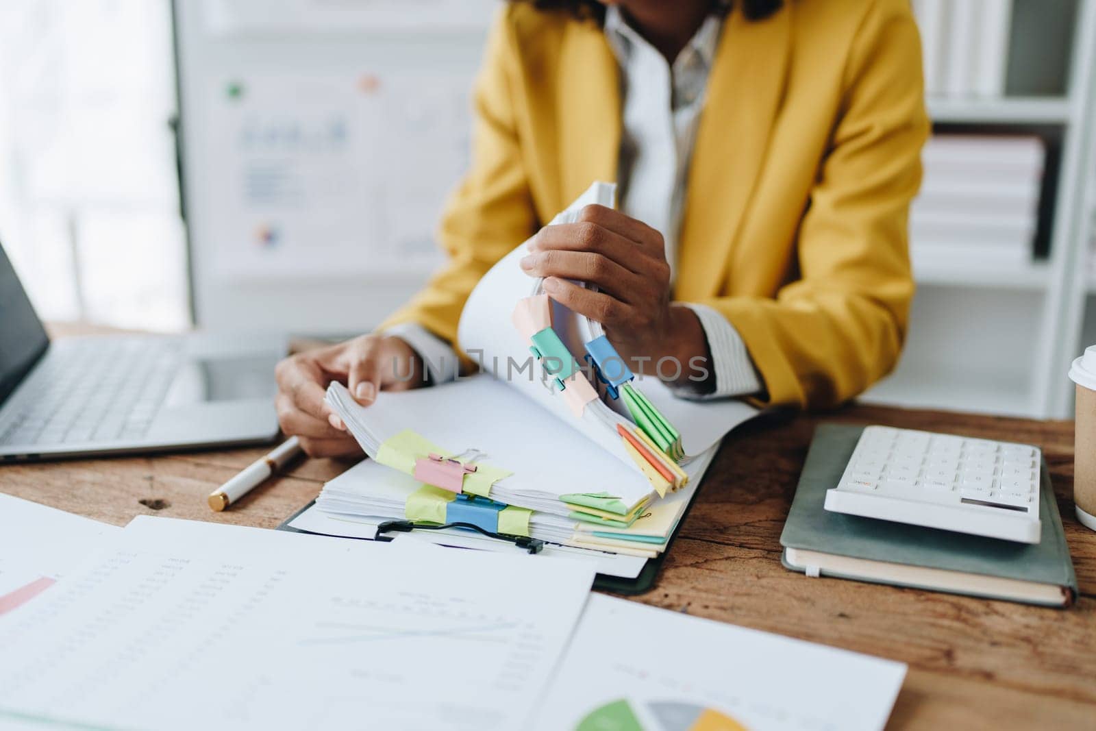 financial, Planning, Marketing and Accounting, portrait of african american employee checking financial statements using documents and calculators at work.