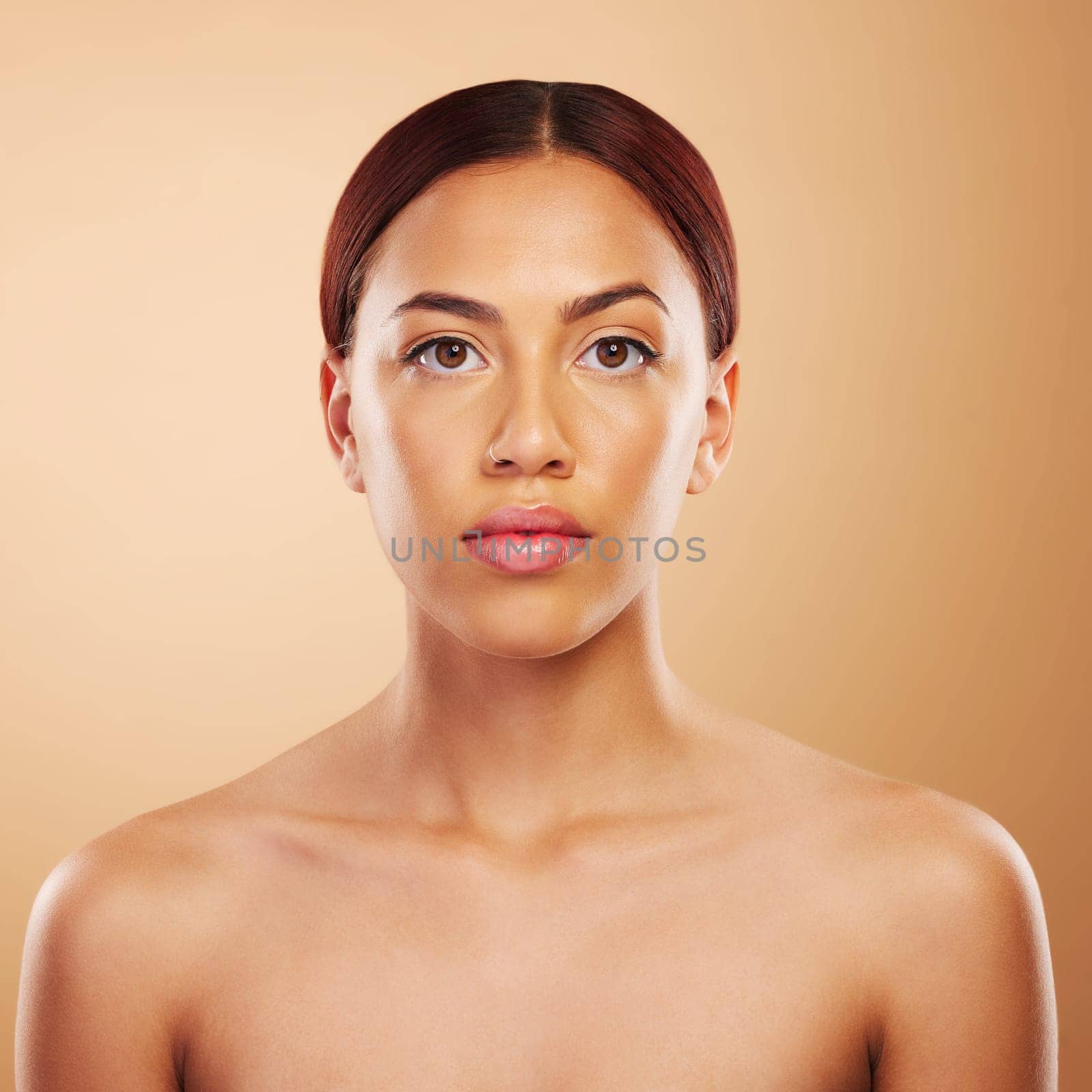 Portrait, skincare and woman with cosmetics, beauty and wellness against a brown studio background. Face, female person and model with makeup, aesthetic and self care with health, glowing and shine.