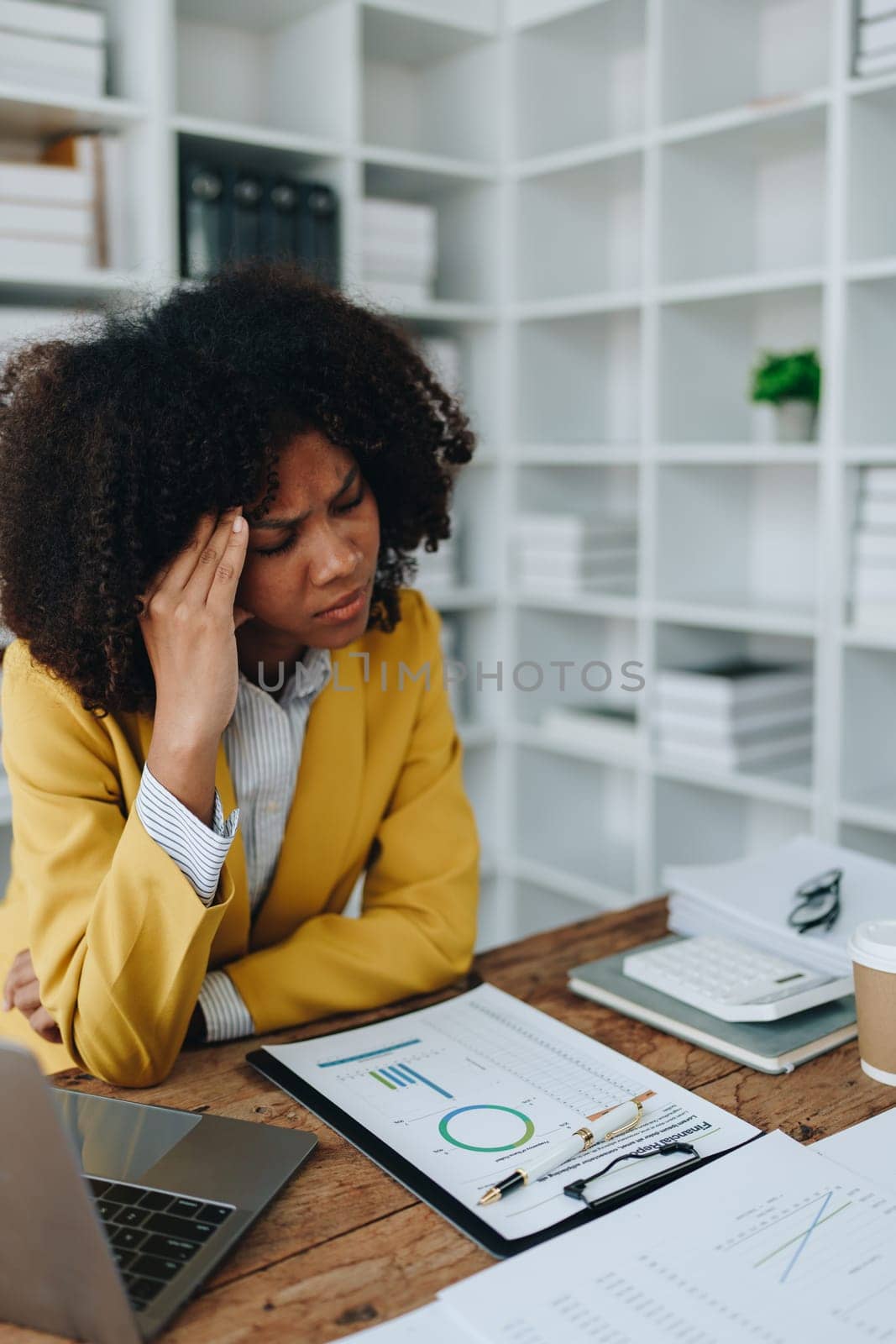 Burnout American African business woman in stress works with many paperwork document, migraine attack, Freelance, work at office by Manastrong