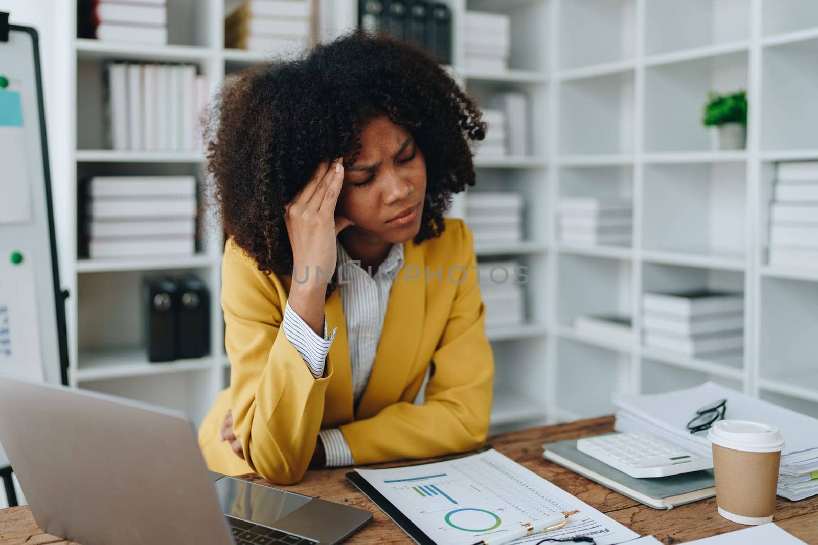 Burnout American African business woman in stress works with many paperwork document, migraine attack, Freelance, work at office.