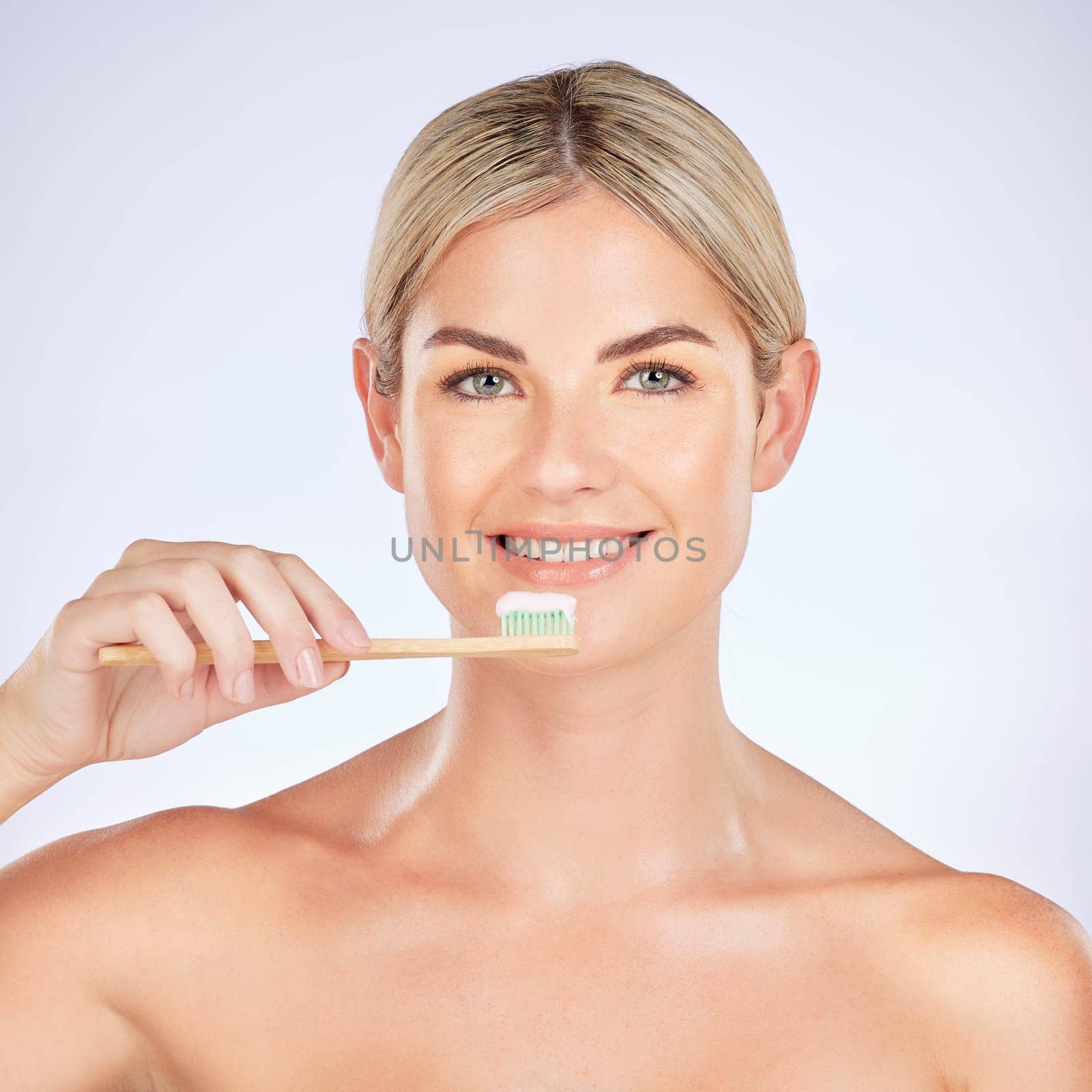 Portrait, woman and brushing teeth in studio for healthy dental wellness on background. Face of female model, bamboo toothbrush and cleaning mouth for fresh breath, oral hygiene and care for smile by YuriArcurs