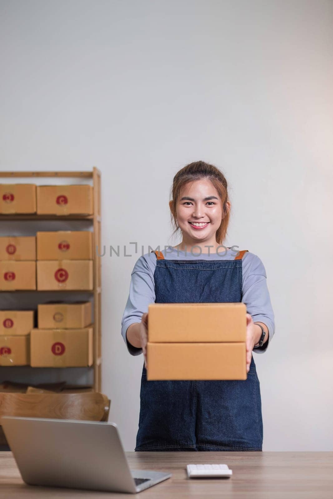 Online business concept, Asian business women holds parcel boxes of product for delivery to client by wichayada