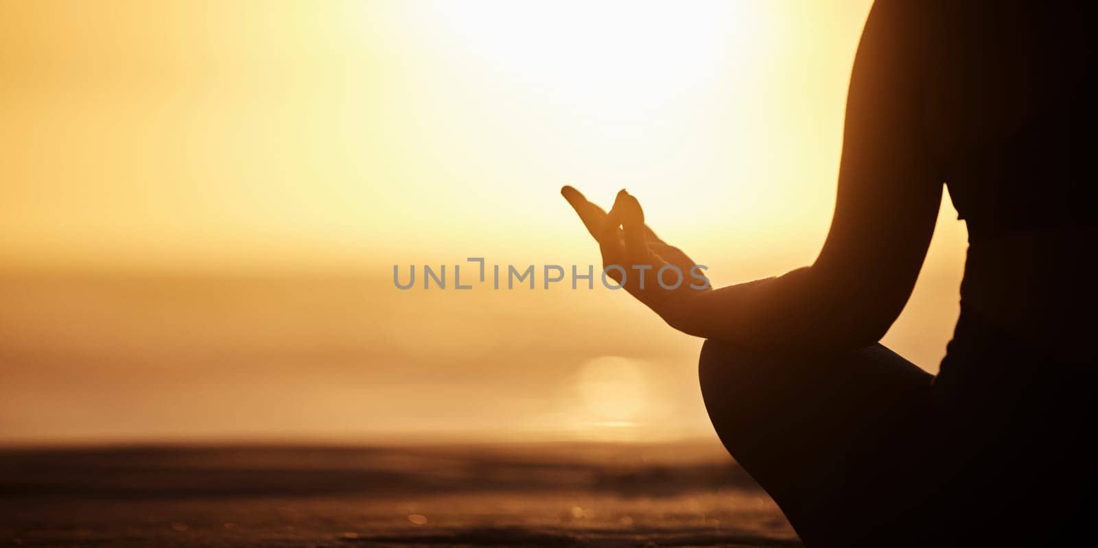 Silhouette, mockup and person doing meditation at the beach for wellness, health and zen or spiritual in morning sunrise. Balance, shadow and athlete meditate or yoga to be calm, workout and healthy by YuriArcurs