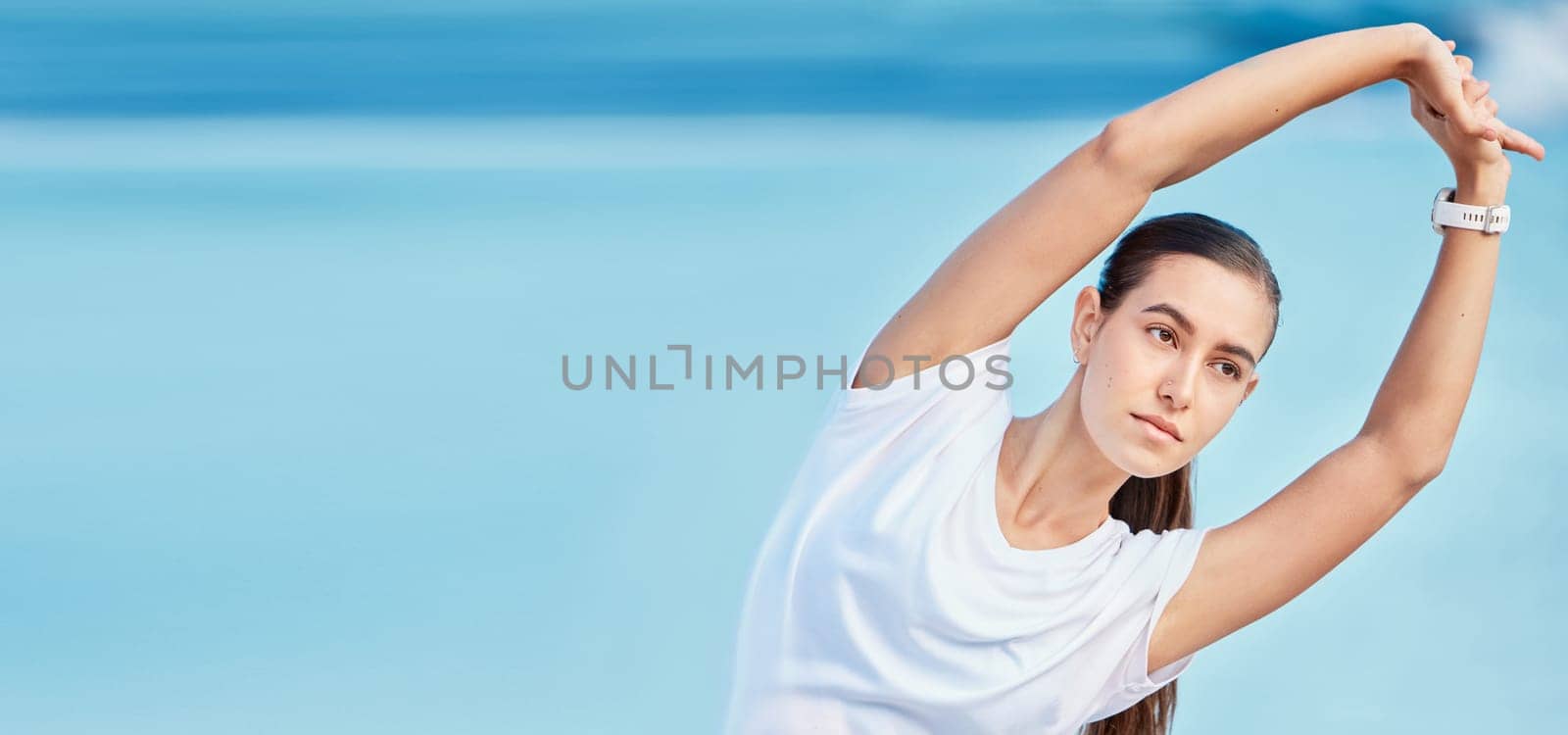 Woman, beach and stretching body on mockup space in fitness, motivation or outdoor workout. Female person or runner in warm up on ocean coast, banner or sports for healthy wellness and exercise by YuriArcurs