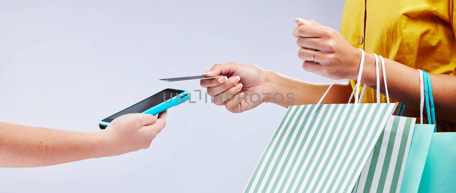 Card machine, shopping and woman hands, POS online payment and digital service or fashion fintech in studio. Bag and credit of customer, cashier or people at point of sale on white background banner by YuriArcurs