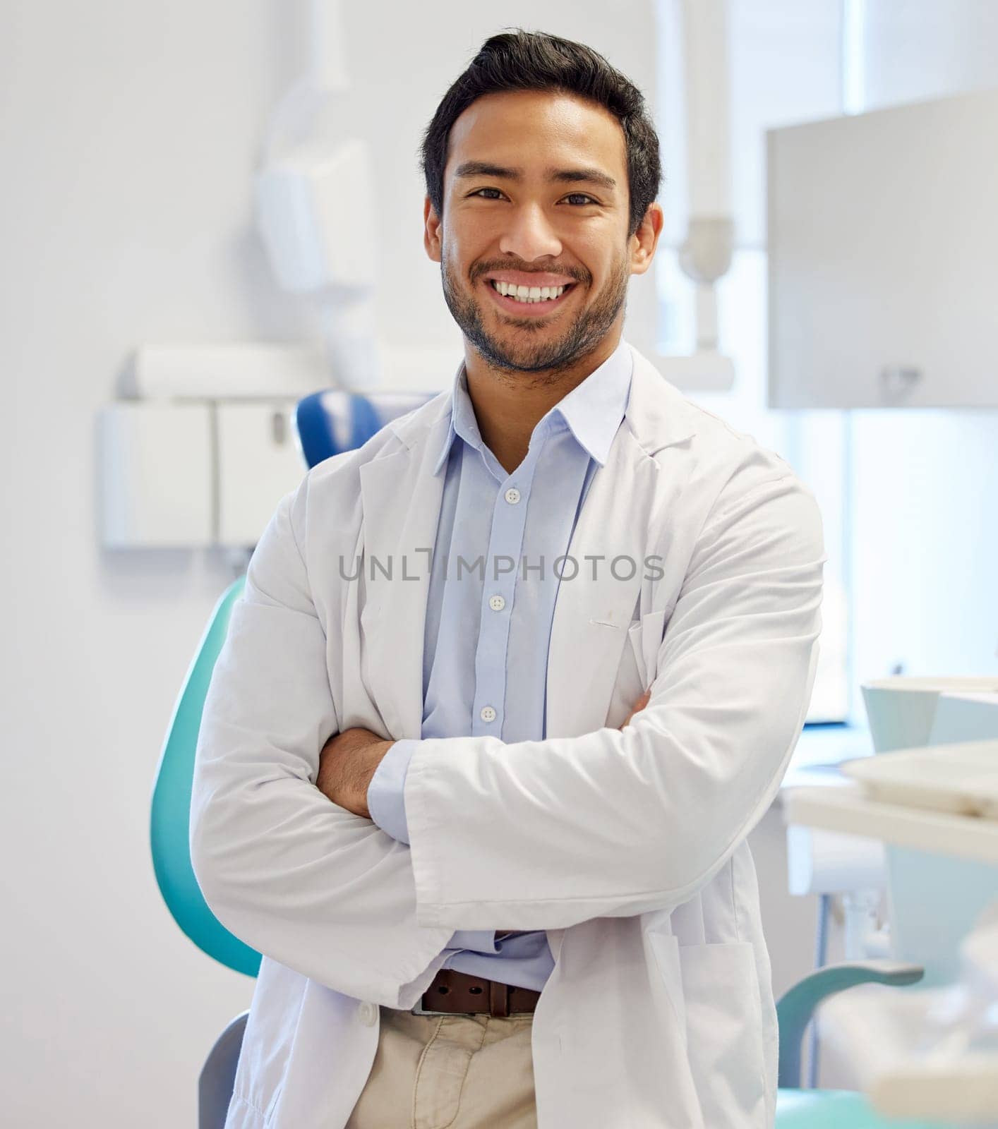 Dentist, portrait and man with arms crossed for healthcare service, dental hospital or insurance in consultation office. Happy asian person or doctor with teeth, oral or hygiene health in clinic.