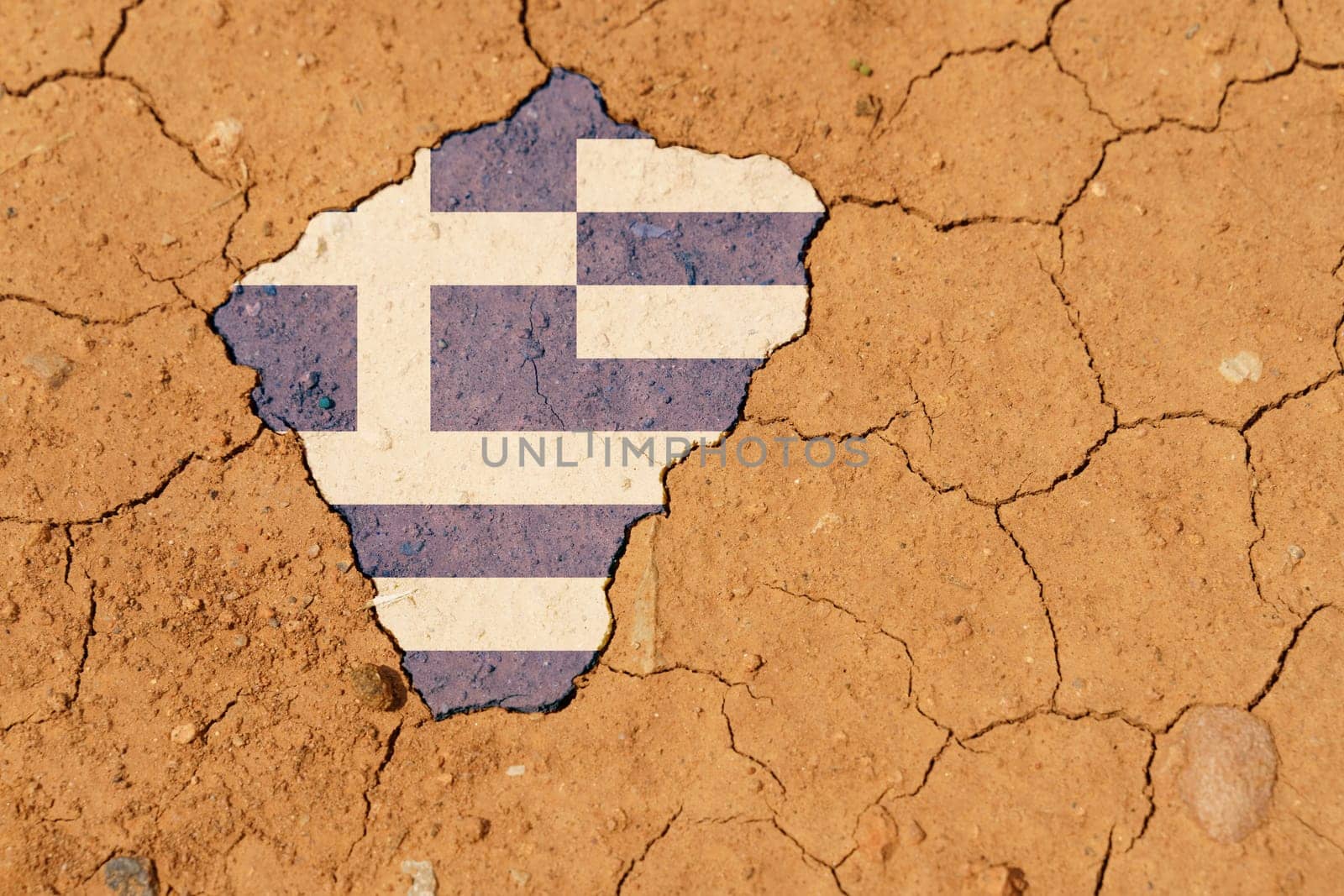 Ecological concept. Drought. On dry, cracked ground, the image of the flag of Greece.