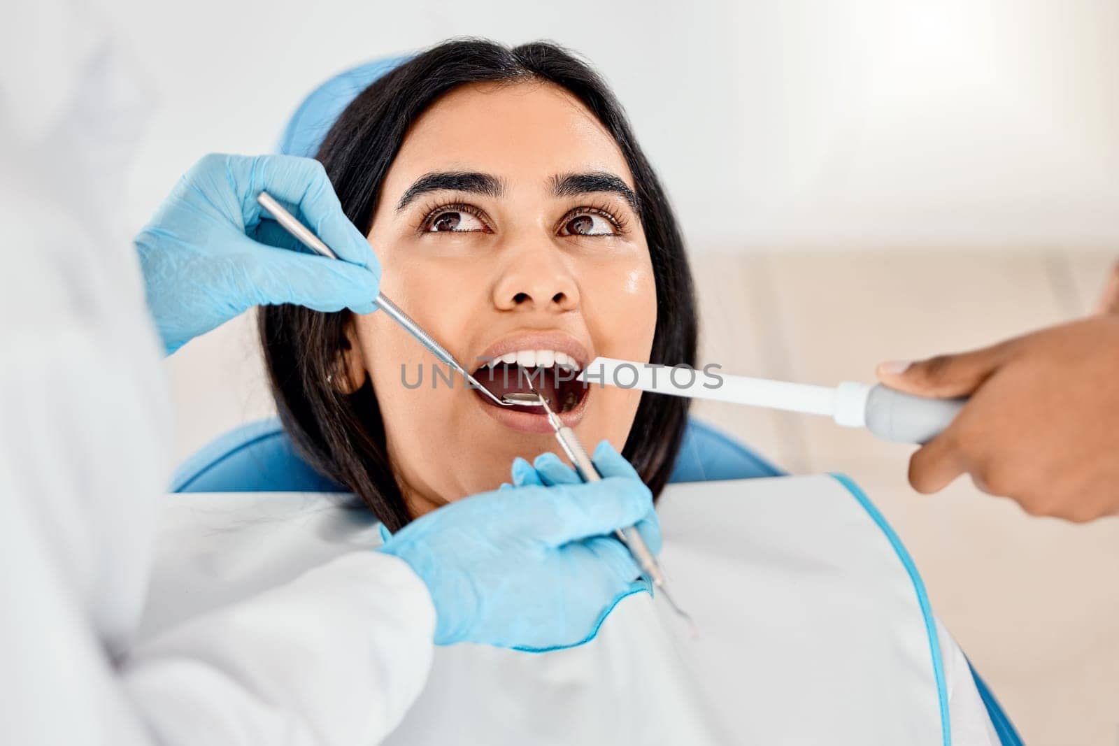 Dentist, woman and patient at a clinic with medical and healthcare for teeth whitening. Mirror, orthodontist and female person with wellness and dental work tool in mouth with care and cleaning.