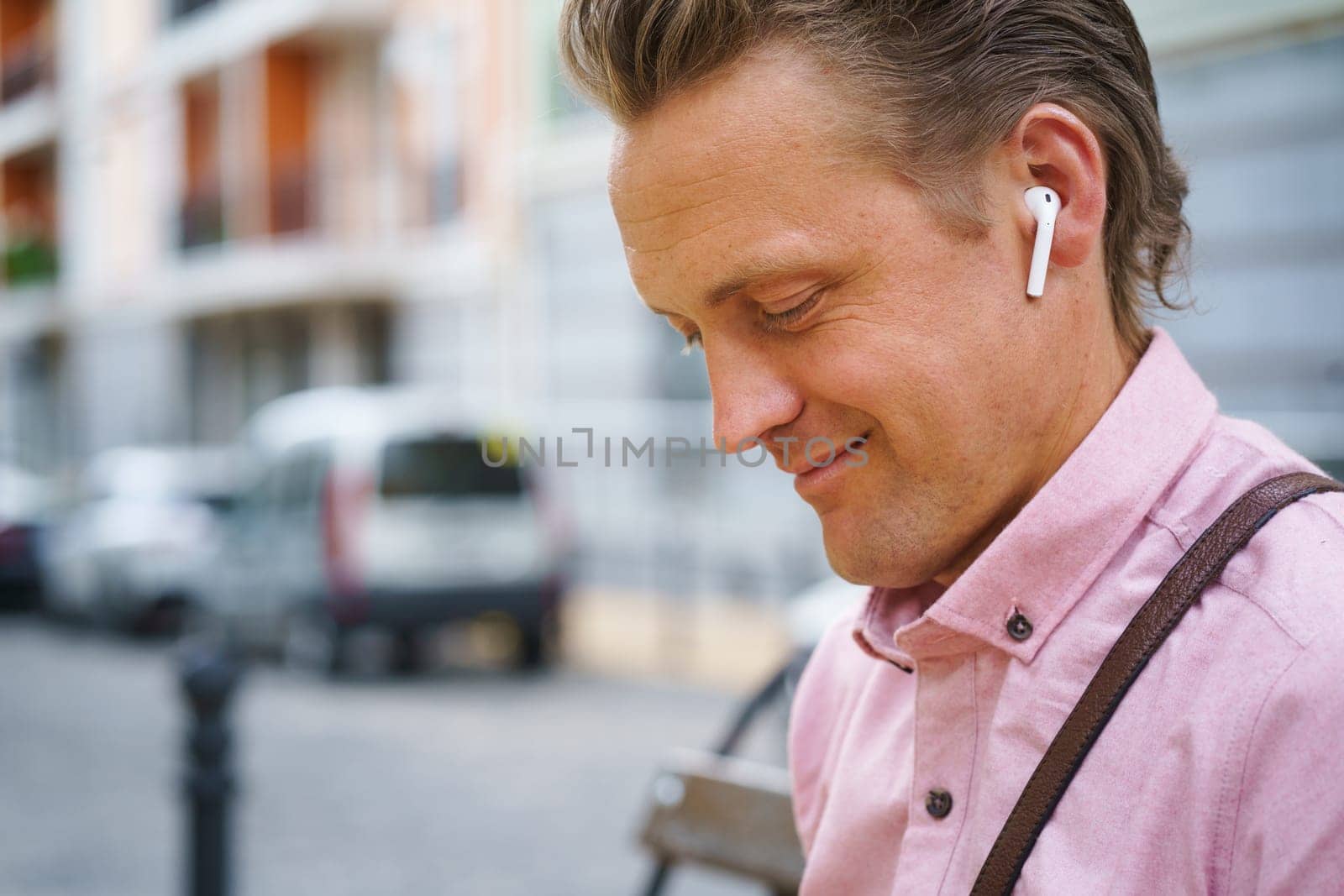 Moment of pure happiness as man with closed eyes enjoys listening to music on bench in bustling urban city. He fully immersed in music, finding relaxation and contentment in melodies. . High quality photo