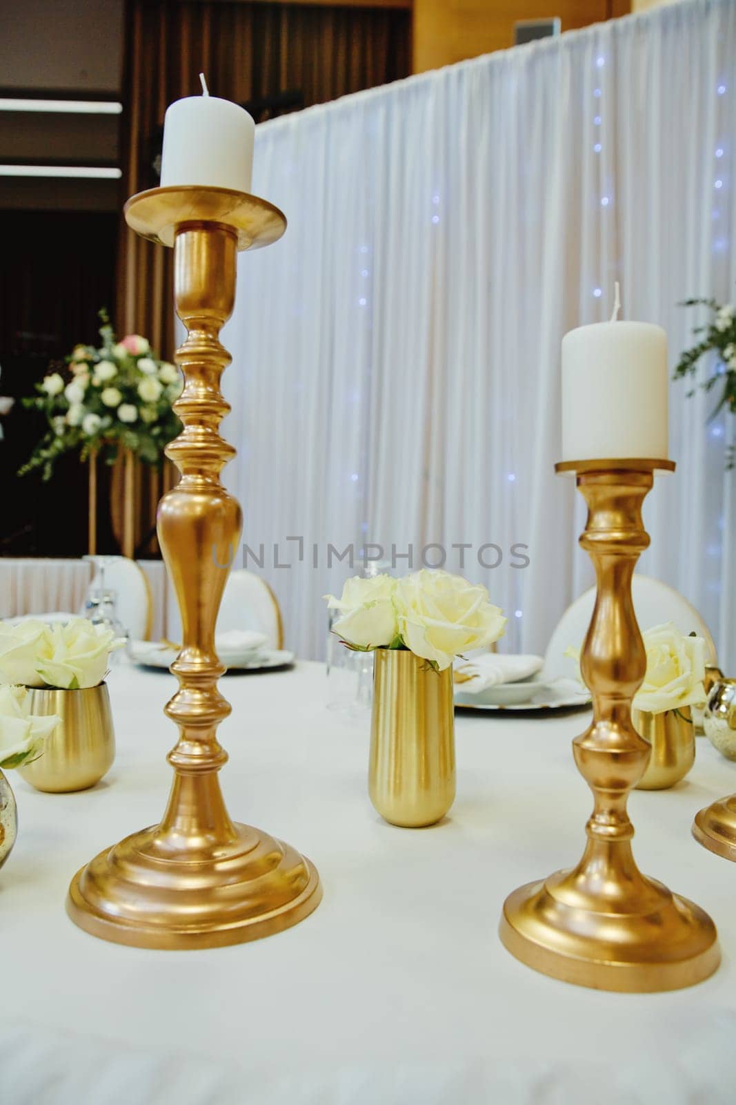Gilded candlestick on a festive wedding table. Elegance wedding decor.