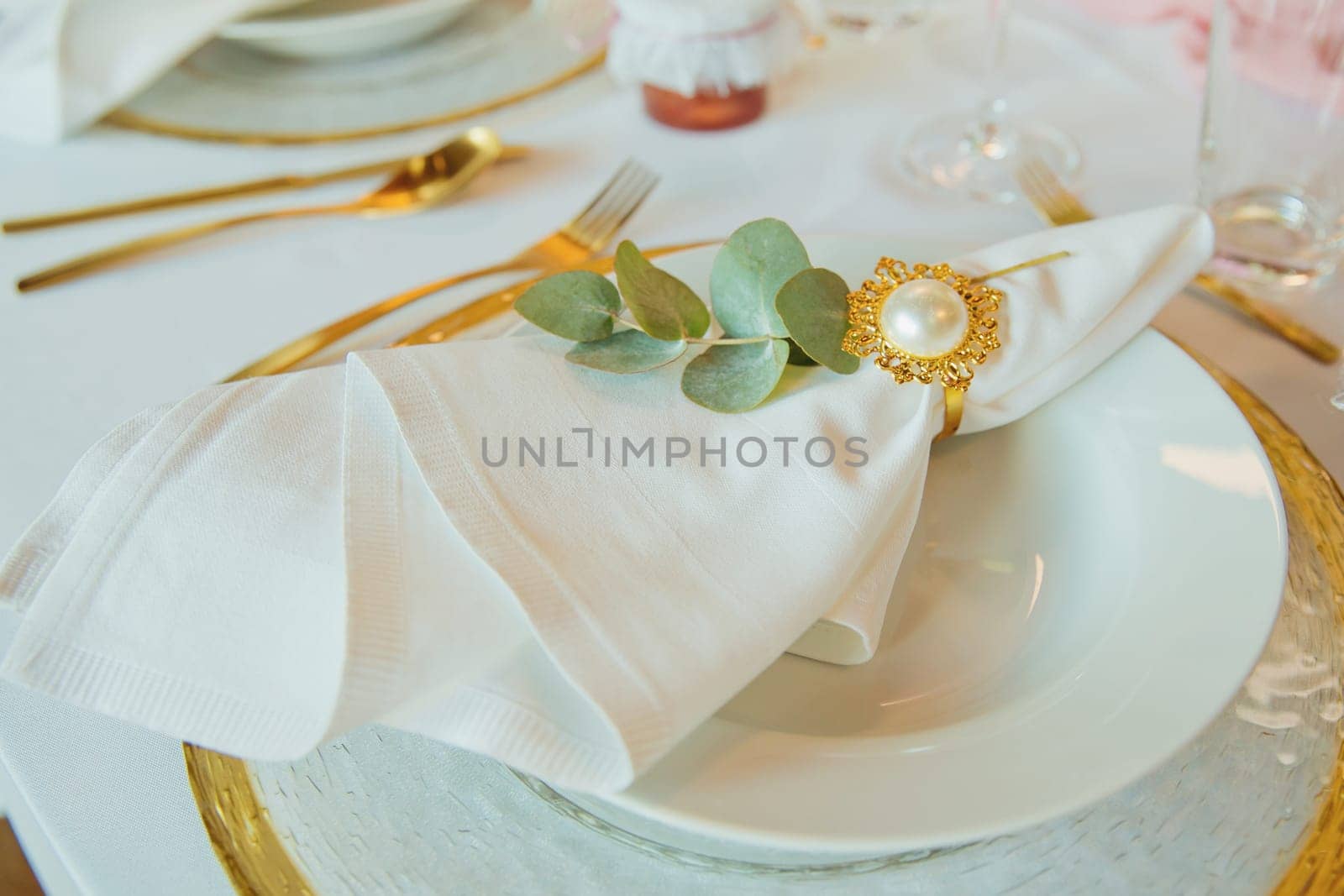 Wedding brunch table setting with a napkin on a plate. Elegance wedding decor. Close-up. by leonik