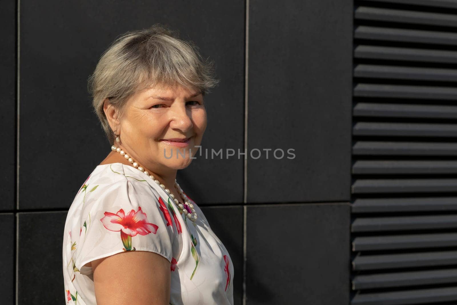 Closeup Real Smiling Senior Old 70s Woman, Dark Wall on Background. Portrait Of Kind Happy Elderly Female, Copy Space For Text. Authentic Lifestyle Horizontal Plane. High quality photo